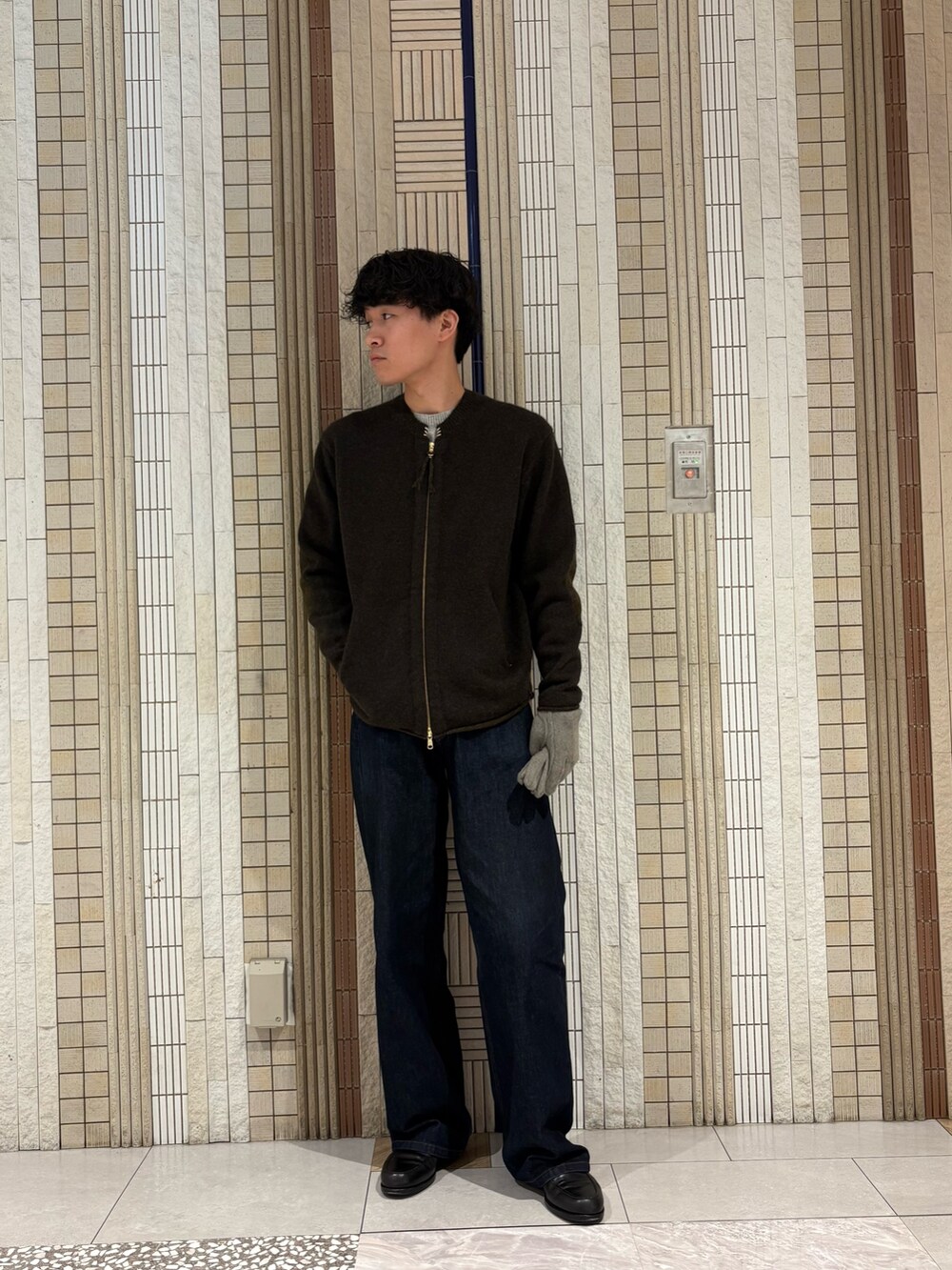 グレー系のニット/セーター、グレー系の手袋を着用したメンズの秋コーディネートの3枚目の写真