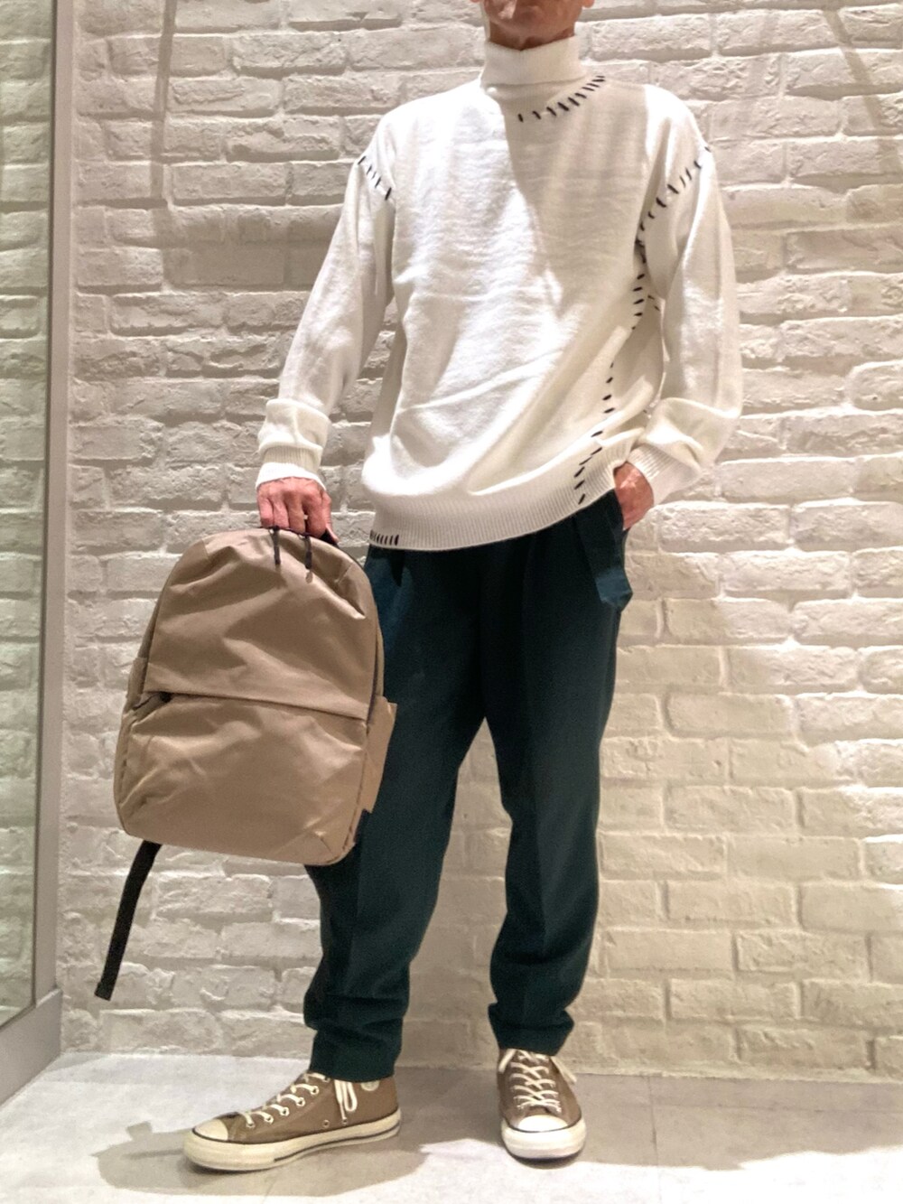 ホワイト系のニット/セーター、グリーン系のその他パンツを着用したメンズの秋コーディネートの2枚目の写真