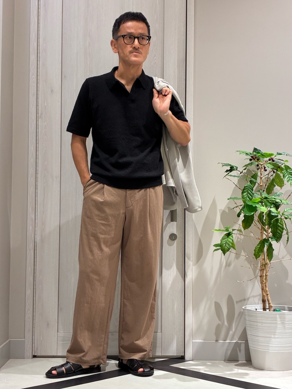 ベージュ系のカーディガン/ボレロ、ブラック系のポロシャツ、ブラウン系のその他パンツを着用したメンズの秋コーディネートの2枚目の写真