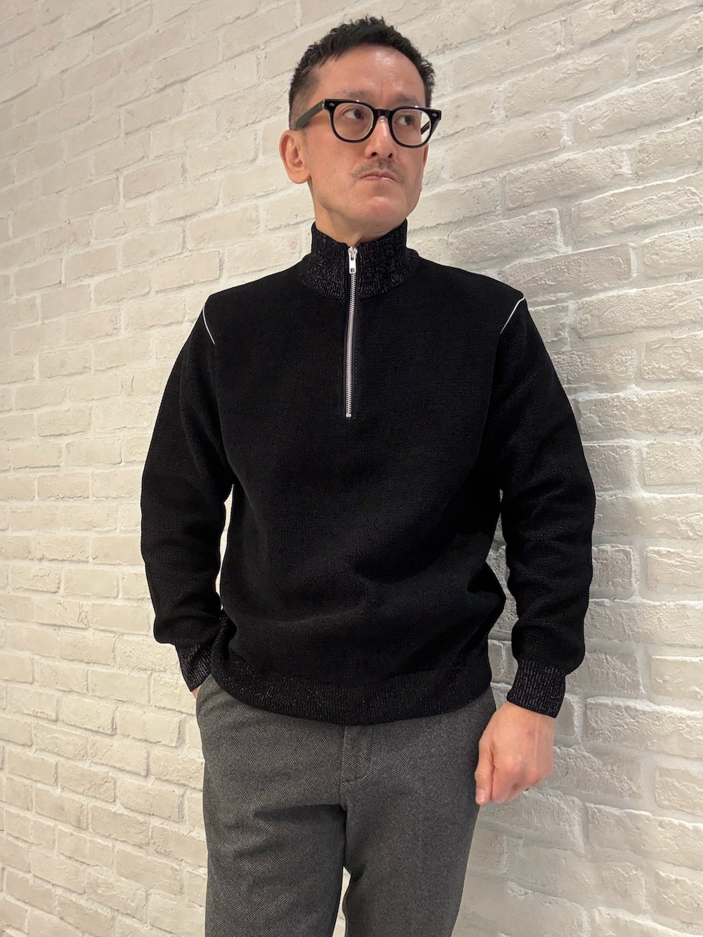 ブルー系のブルゾン、ブラック系のニット/セーター、ブラック系のスラックスを着用したメンズの冬コーディネートの3枚目の写真