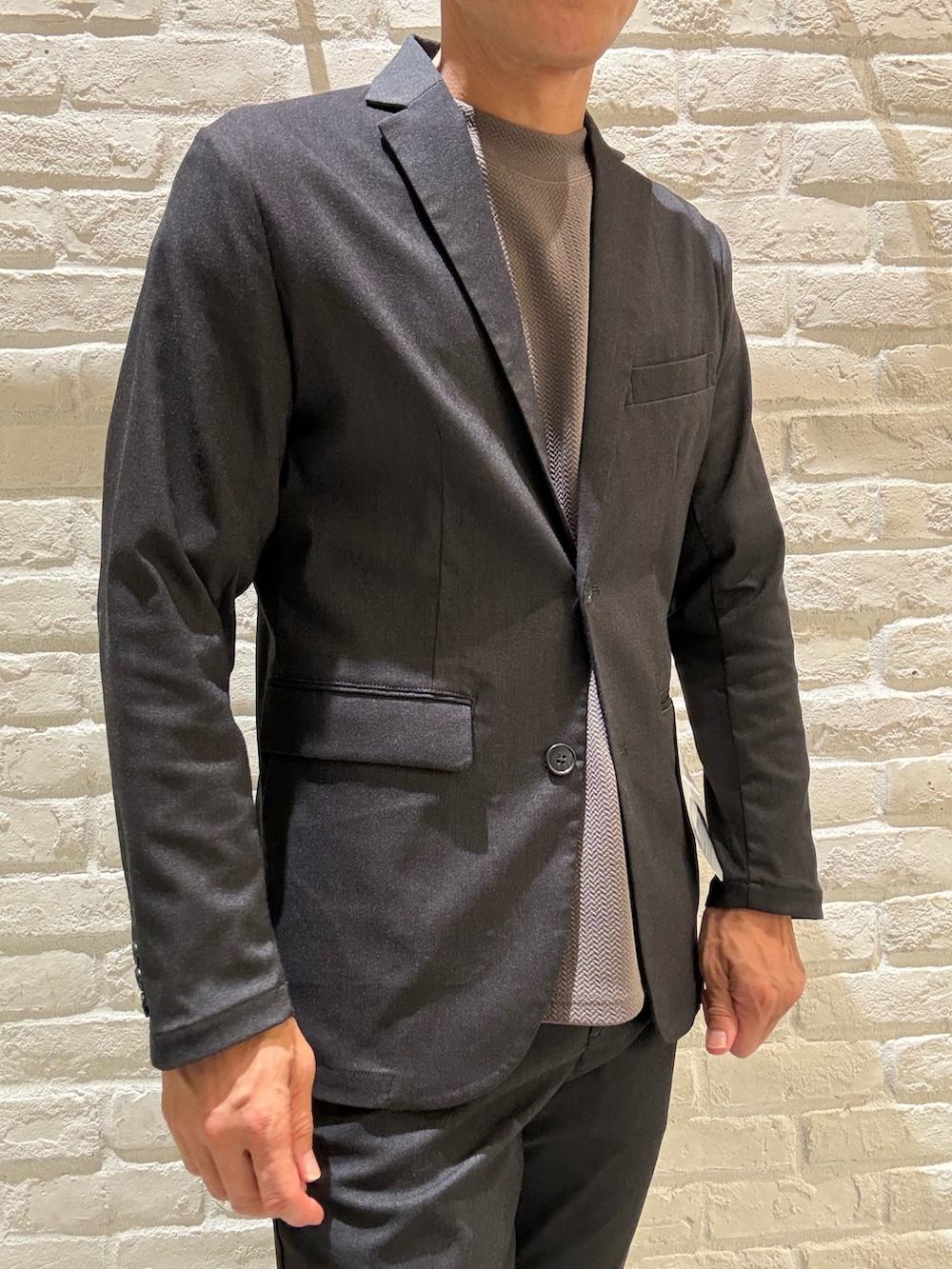 ブラック系のテーラードジャケット、ブラック系のセットアップ、ブラウン系のTシャツ/カットソーを着用したメンズの夏コーディネートの3枚目の写真
