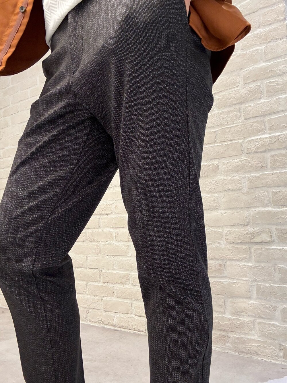 オレンジ系のシャツ/ブラウス、ブラック系のスラックス、ホワイト系のTシャツ/カットソーを着用したメンズの秋コーディネートの4枚目の写真