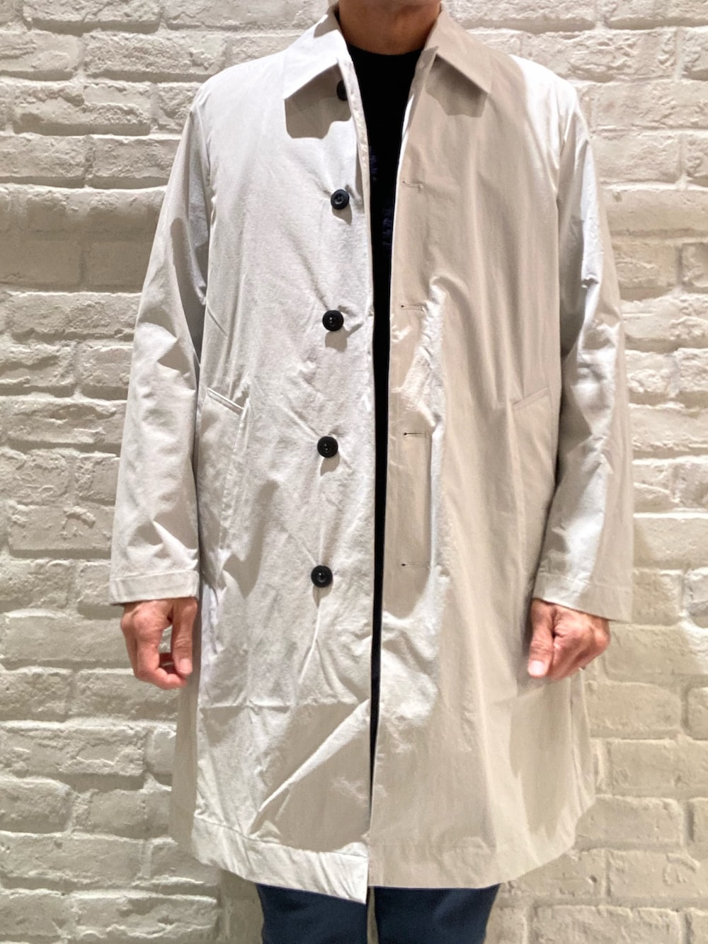 ベージュ系のステンカラーコート、ブルー系のテーラードジャケット、ブルー系のニット/セーターを着用したメンズの冬コーディネートの4枚目の写真