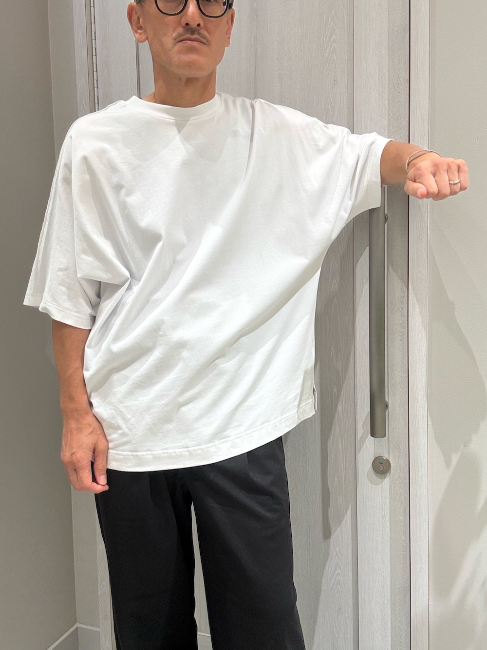 ブルー系のバックパック/リュック、ホワイト系のTシャツ/カットソー、ブラック系のその他パンツを着用したメンズの夏コーディネートの5枚目の写真