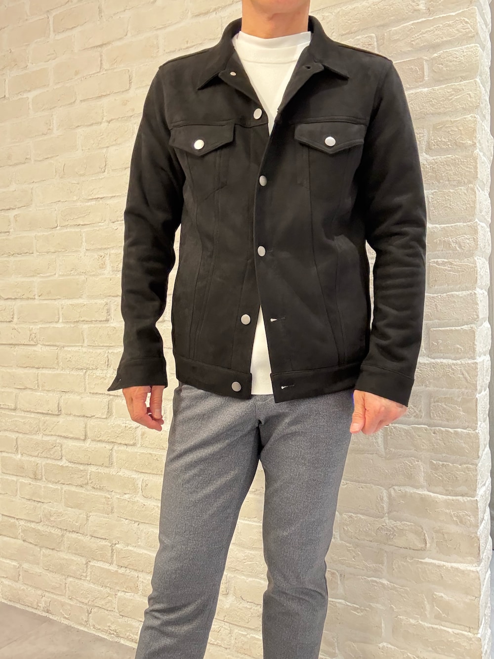 ブラック系のブルゾン、ホワイト系のTシャツ/カットソー、その他のスラックスを着用したメンズの春コーディネートの3枚目の写真