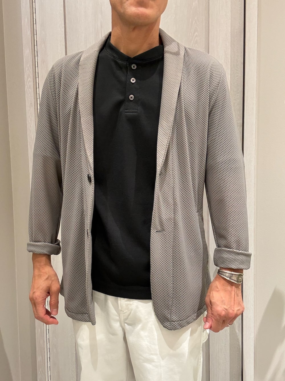 ブラウン系のブルゾン、ブラック系のTシャツ/カットソー、ホワイト系のデニムパンツを着用したメンズの夏コーディネートの2枚目の写真
