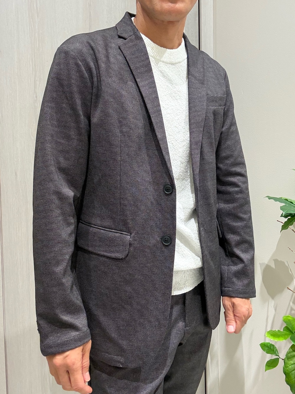 グレー系のセットアップ、グレー系のテーラードジャケット、ホワイト系のTシャツ/カットソーを着用したメンズの秋コーディネートの3枚目の写真