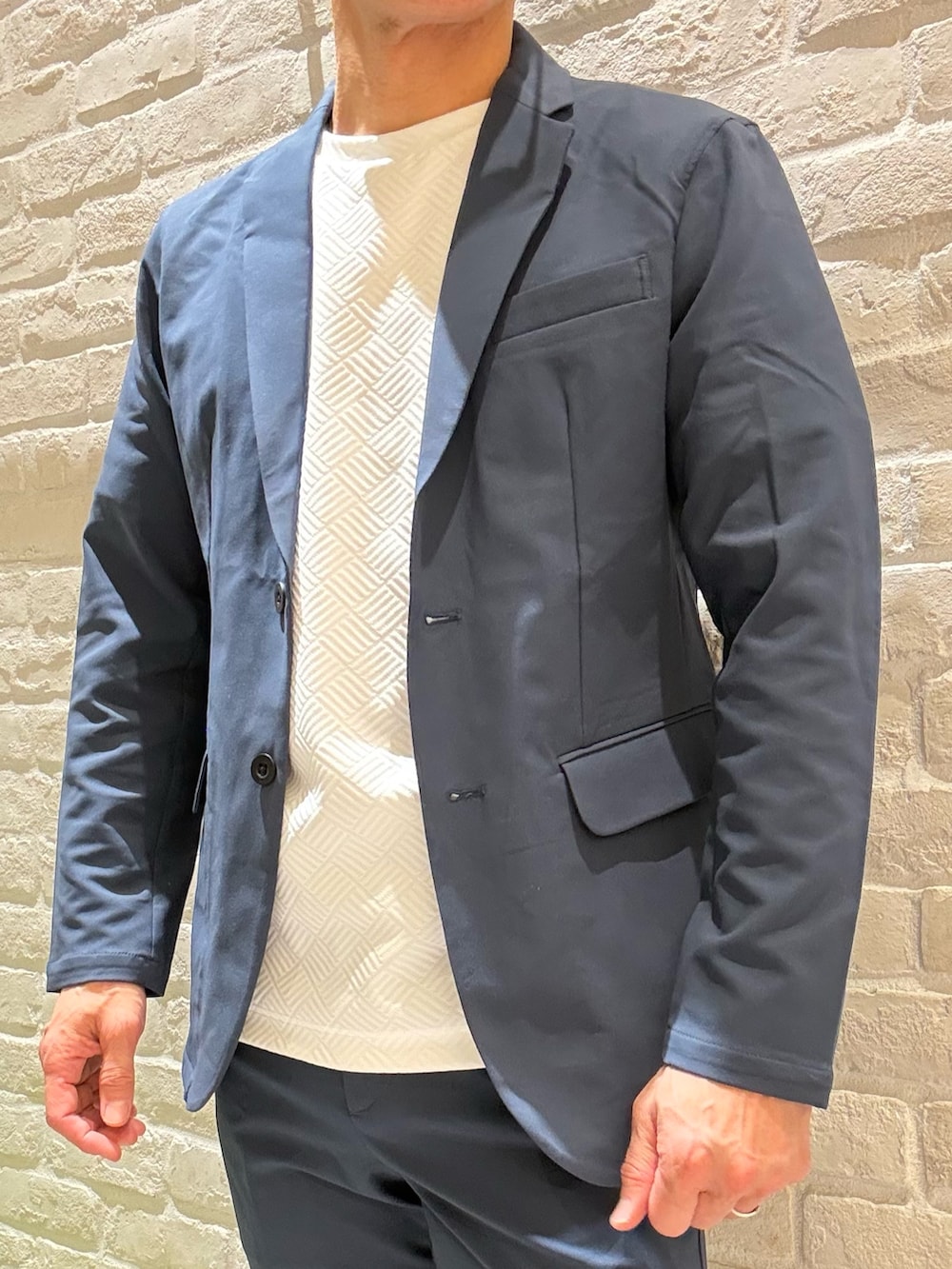 ブラック系のバックパック/リュック、ホワイト系のTシャツ/カットソー、ブルー系のテーラードジャケットを着用したメンズの春コーディネートの5枚目の写真