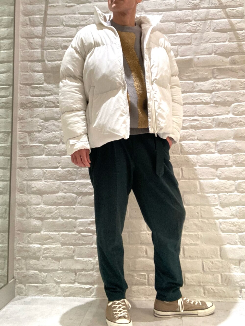 ホワイト系のブルゾン、グレー系のニット/セーター、グリーン系のその他パンツを着用したメンズの冬コーディネートの2枚目の写真