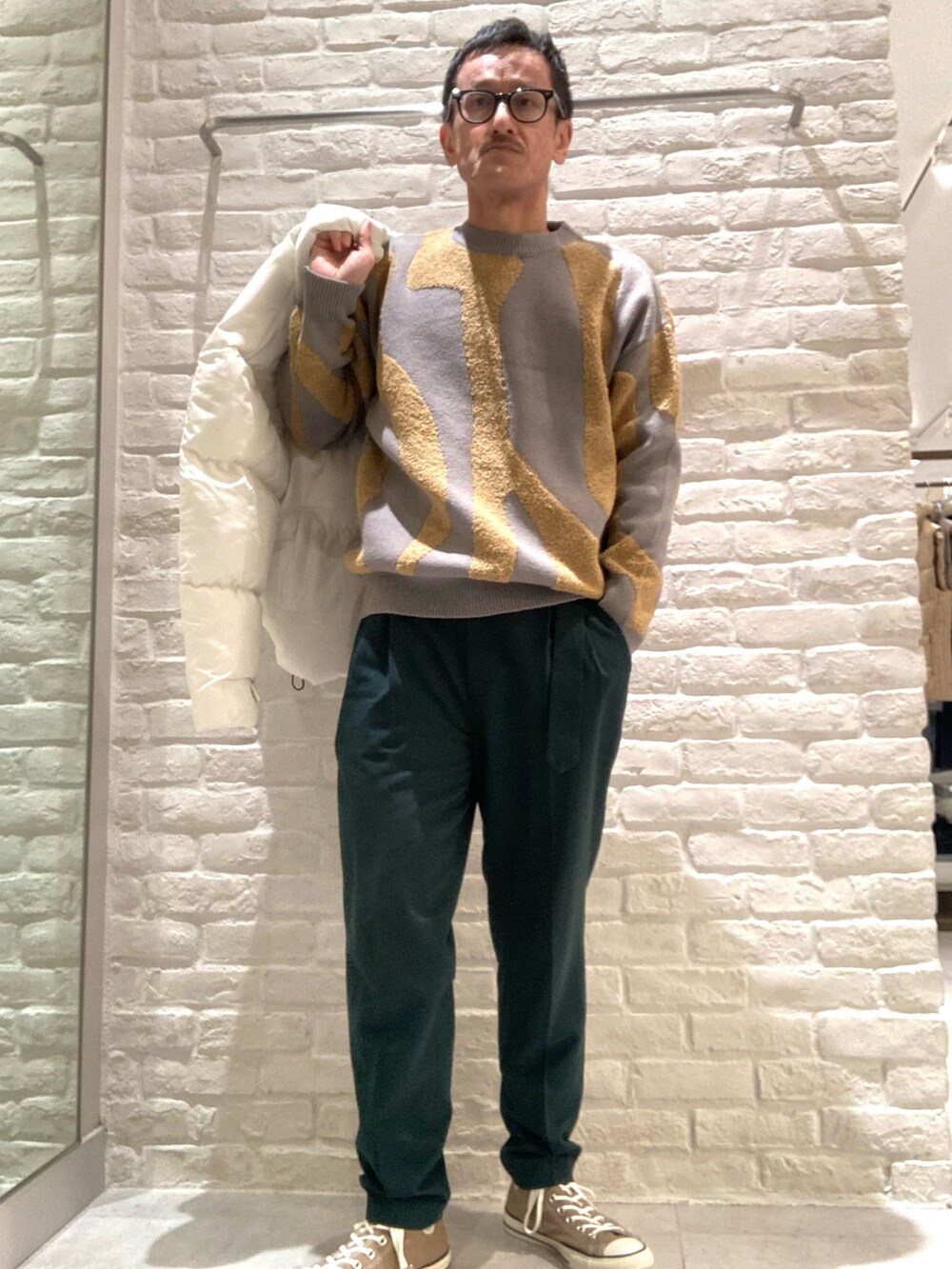 ホワイト系のブルゾン、グレー系のニット/セーター、グリーン系のその他パンツを着用したメンズの冬コーディネートの3枚目の写真