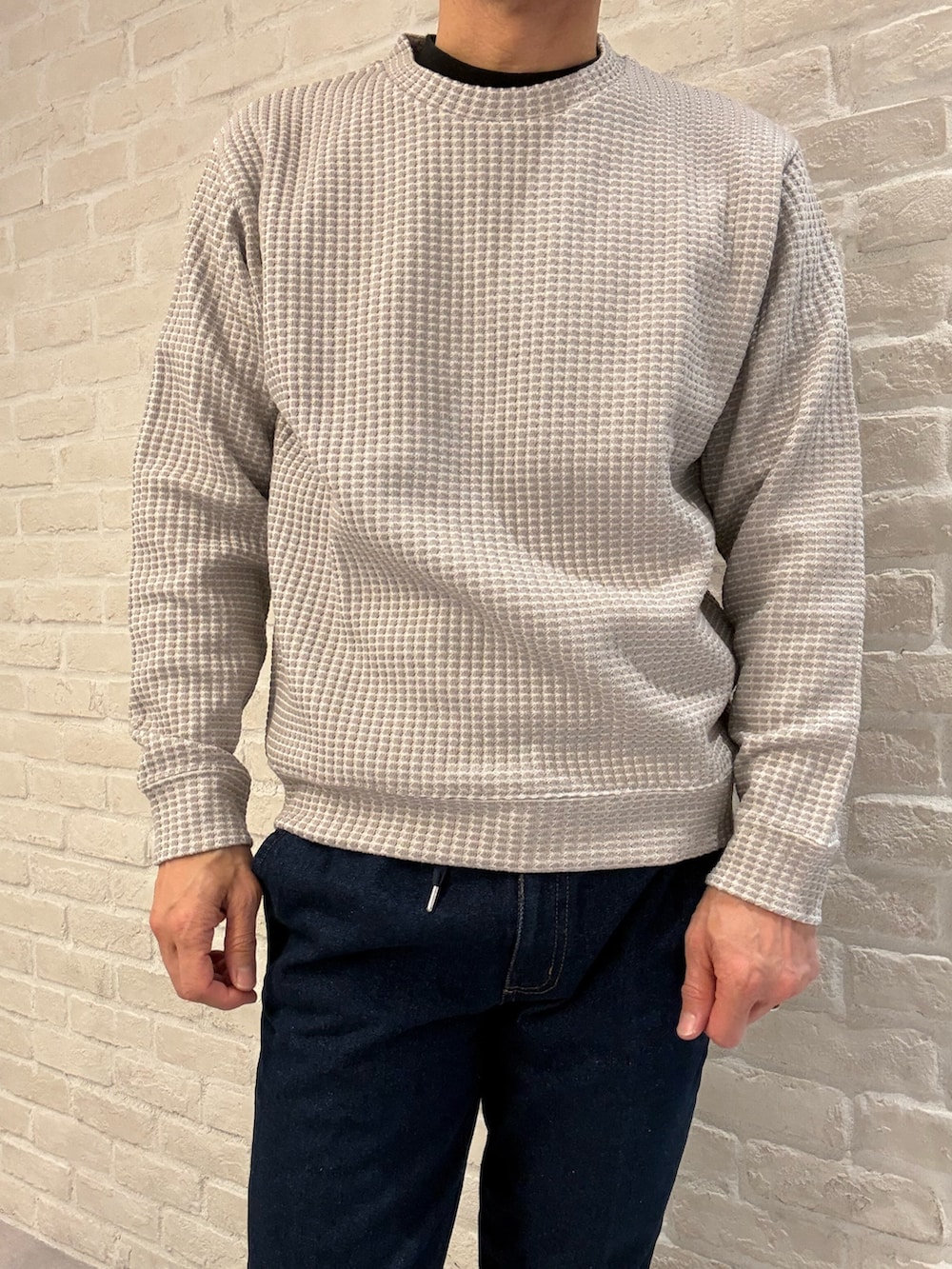 グリーン系のブルゾン、ベージュ系のTシャツ/カットソー、ブルー系のデニムパンツを着用したメンズの冬コーディネートの5枚目の写真