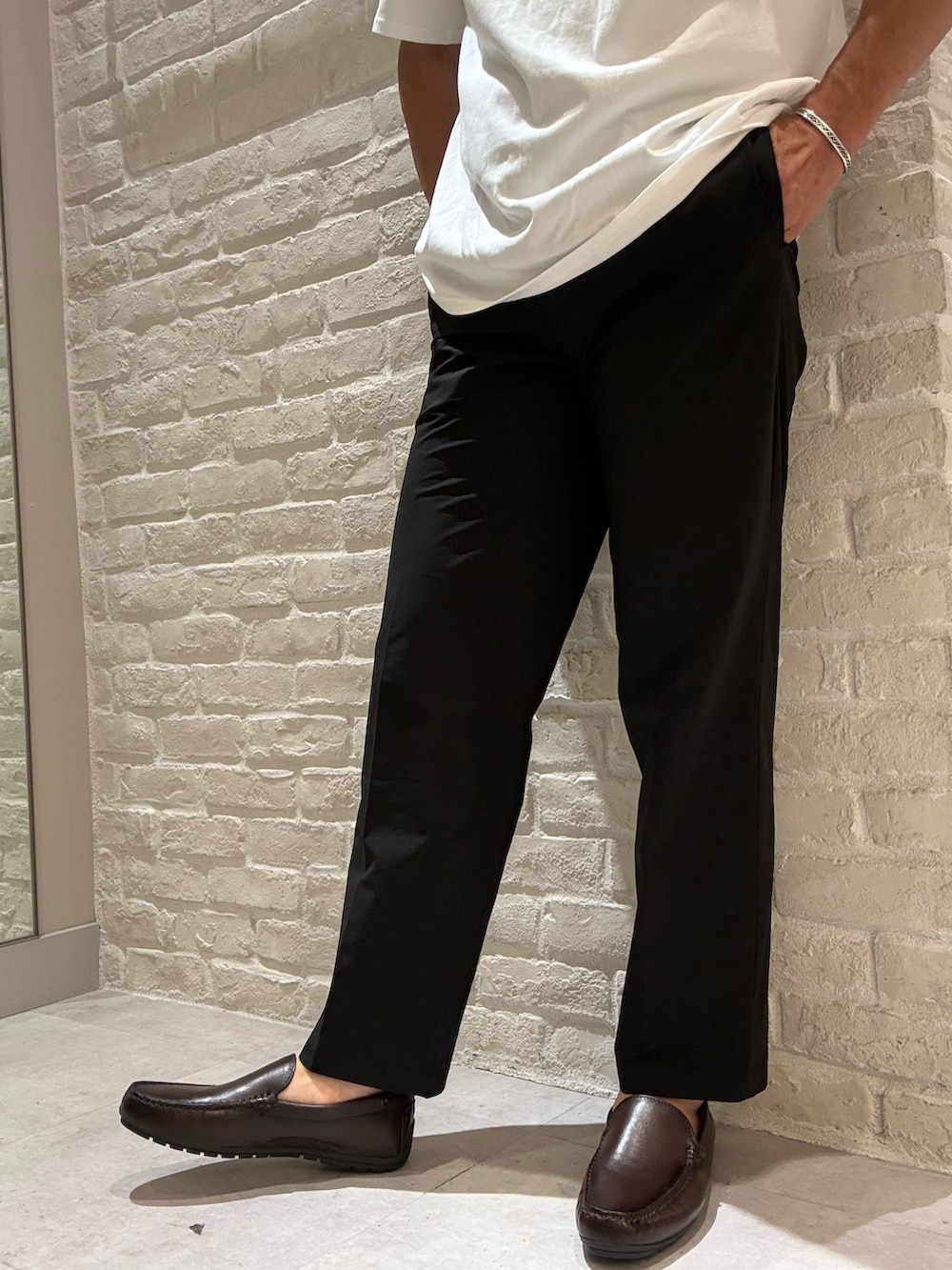 ブラウン系のブルゾン、ホワイト系のTシャツ/カットソー、ブラック系のその他パンツを着用したメンズの夏コーディネートの4枚目の写真