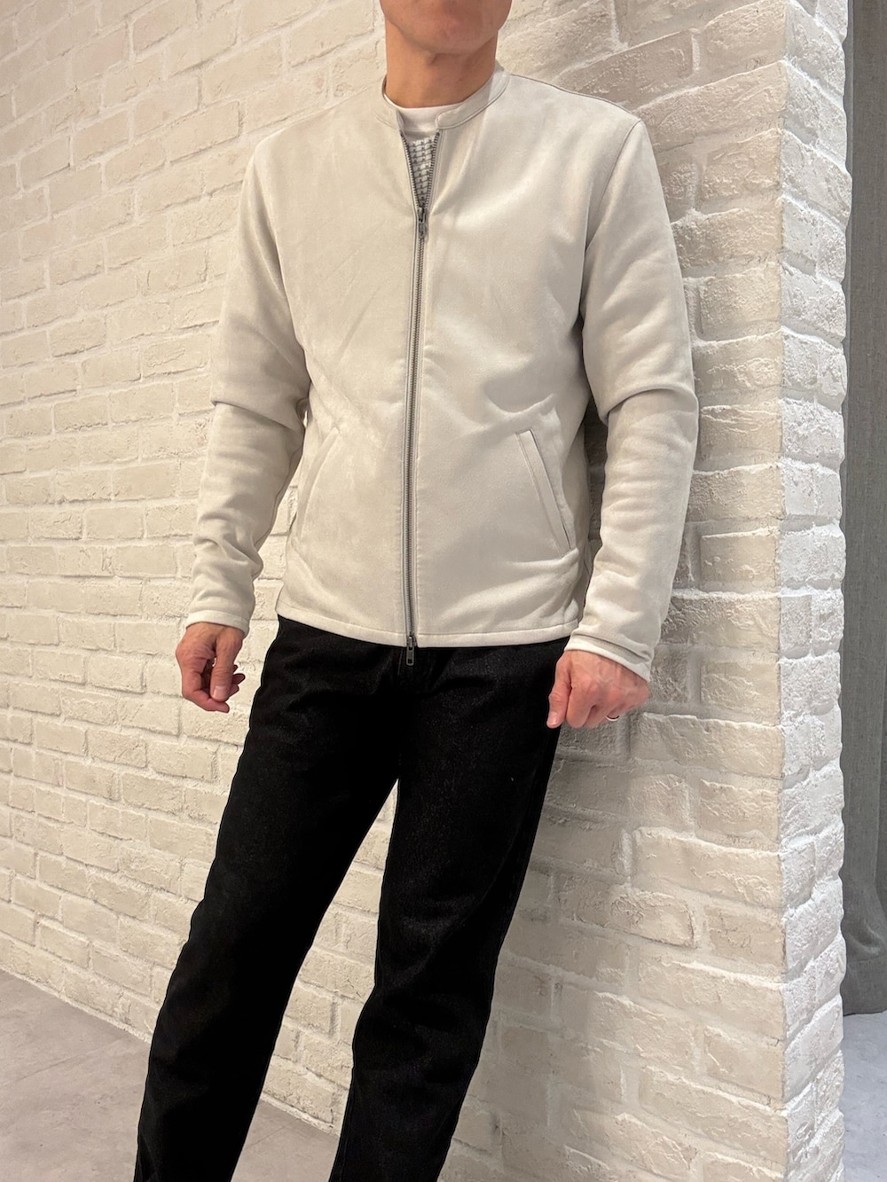 ベージュ系のライダースジャケット、ホワイト系のTシャツ/カットソー、ブラック系のデニムパンツを着用したメンズの春コーディネートの2枚目の写真