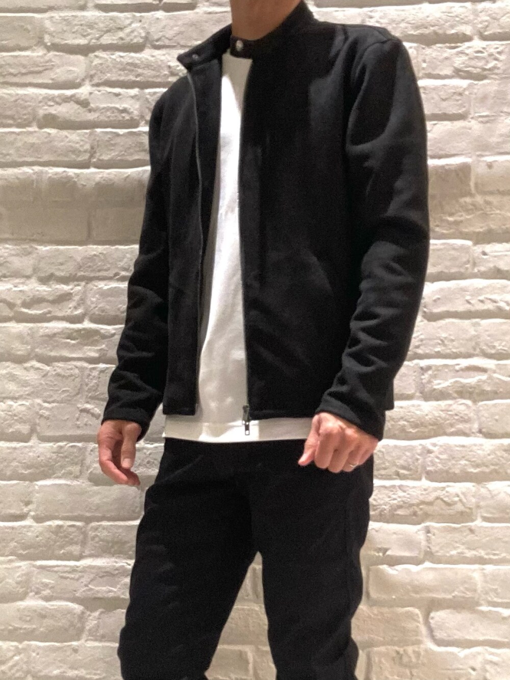 ブラック系のブルゾン、ホワイト系のTシャツ/カットソー、ブラック系のチノパンツを着用したメンズの秋コーディネートの2枚目の写真