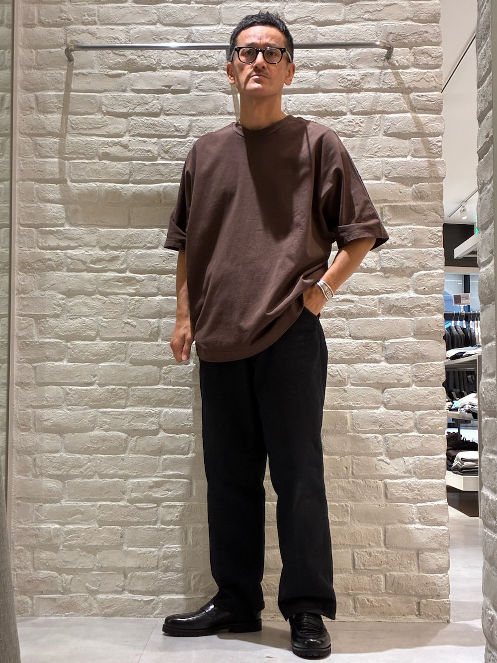 ブラウン系のTシャツ/カットソー、イエロー系のトートバッグ、ベージュ系のキャップを着用したメンズの夏コーディネートの4枚目の写真