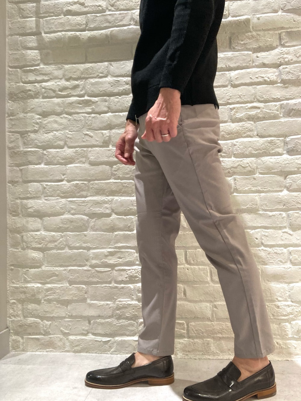 ベージュ系のステンカラーコート、ブラック系のニット/セーター、ブラック系のカーディガン/ボレロを着用したメンズの冬コーディネートの5枚目の写真