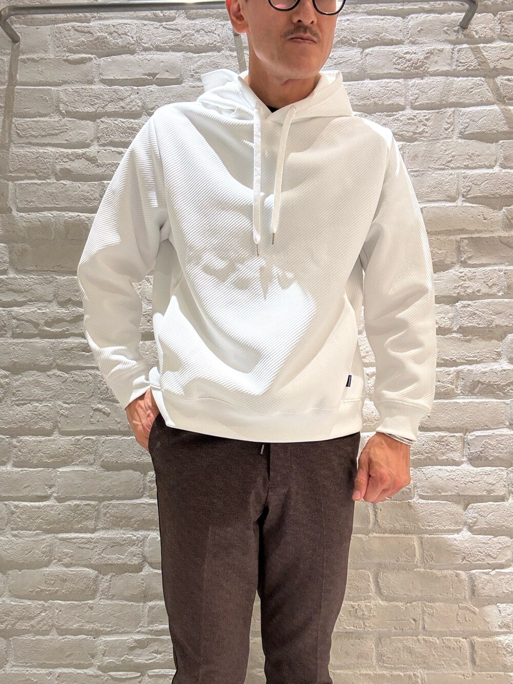 ブラック系のライダースジャケット、ホワイト系のパーカー、その他のスラックスを着用したメンズの秋コーディネートの4枚目の写真