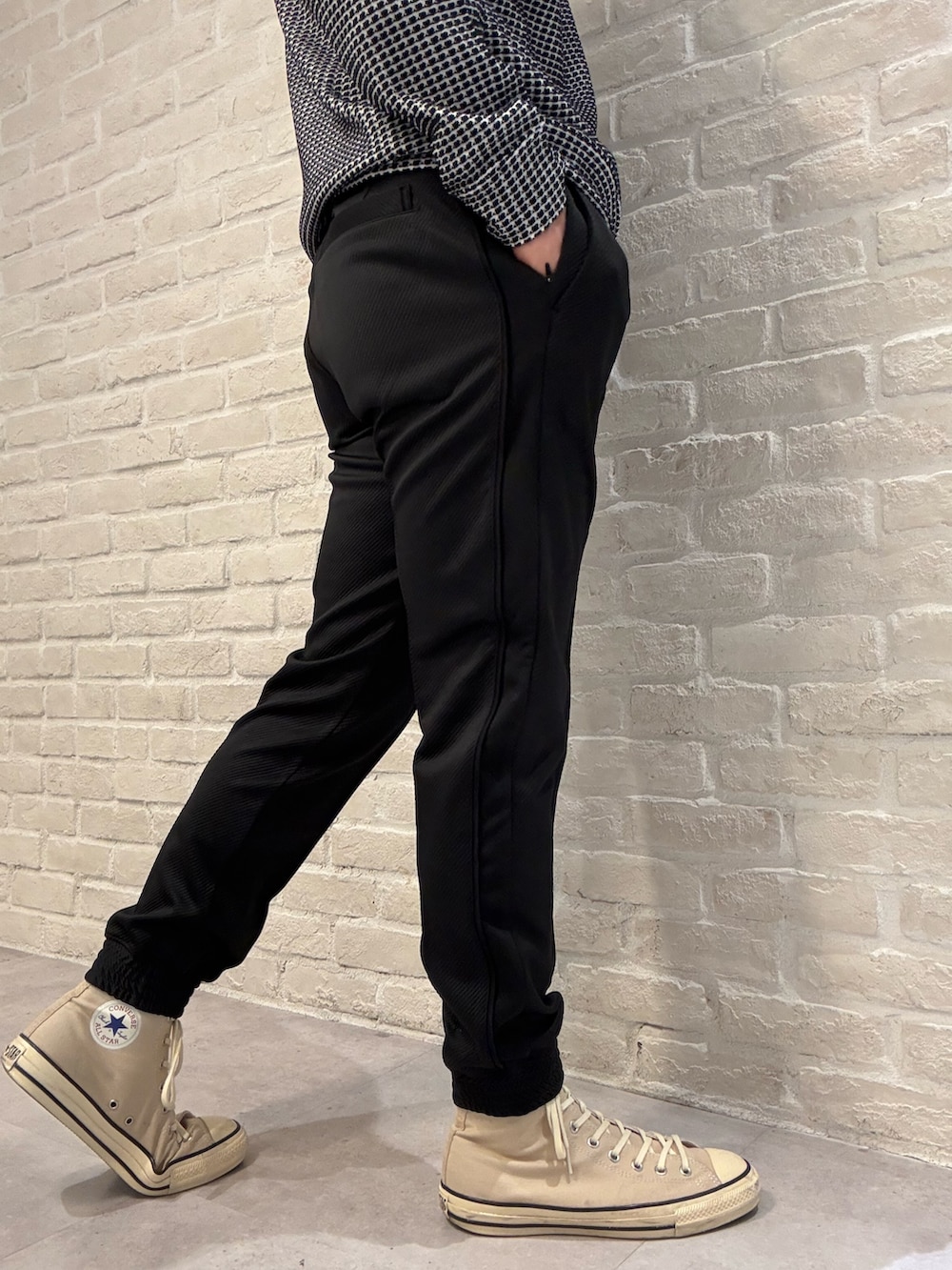 ブラック系のTシャツ/カットソー、グレー系のダウンジャケット/コート、ブラック系のその他パンツを着用したメンズの冬コーディネートの6枚目の写真