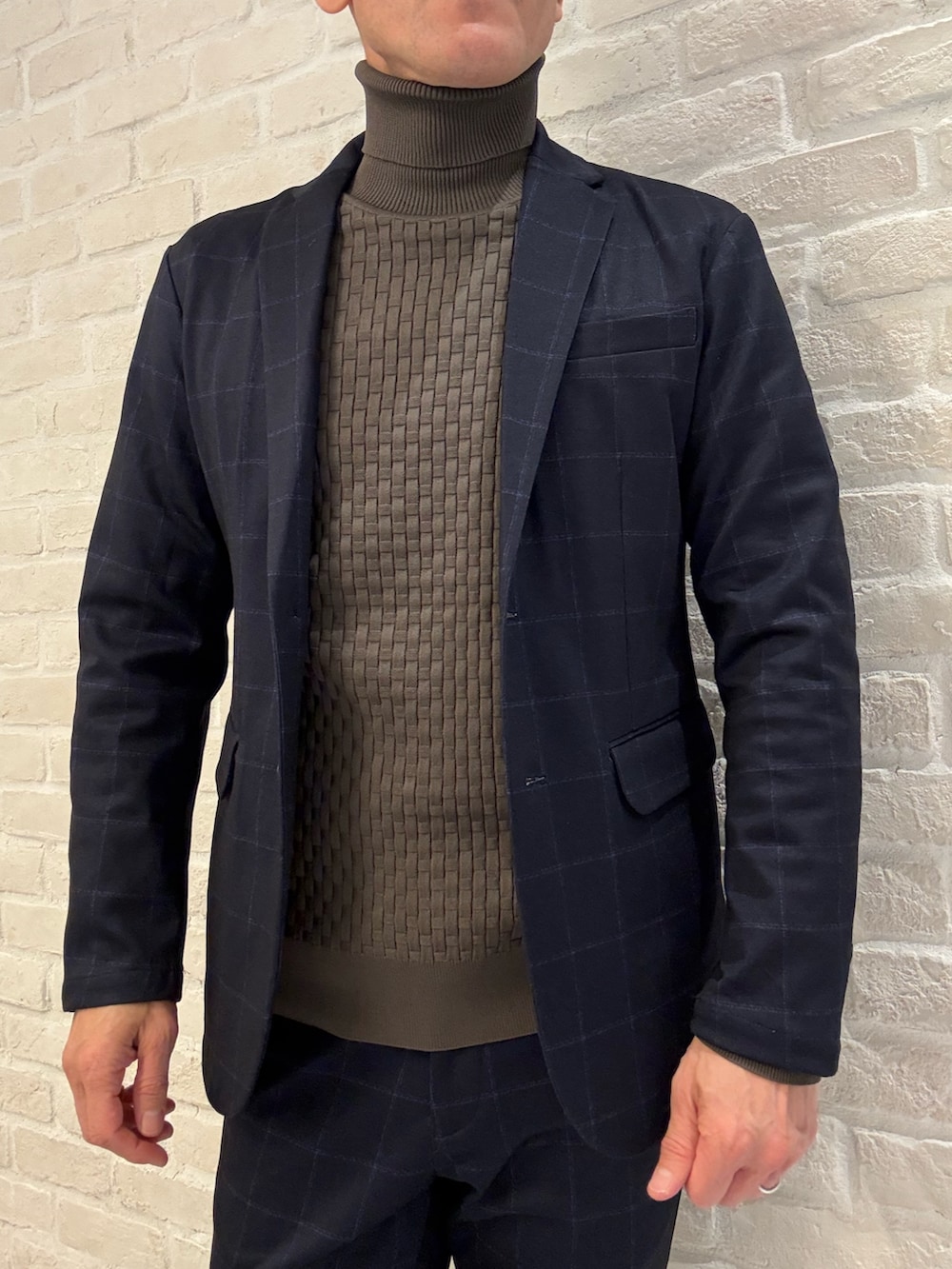 ブルー系のスラックス、ブルー系のテーラードジャケット、ブラウン系のニット/セーターを着用したメンズの冬コーディネートの3枚目の写真