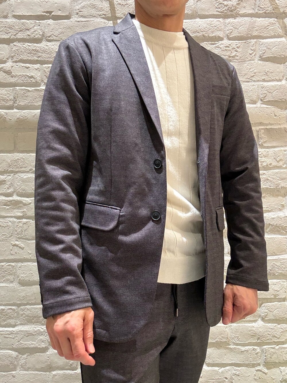 グレー系のテーラードジャケット、グレー系のセットアップ、グレー系のスラックスを着用したメンズの冬コーディネートの2枚目の写真
