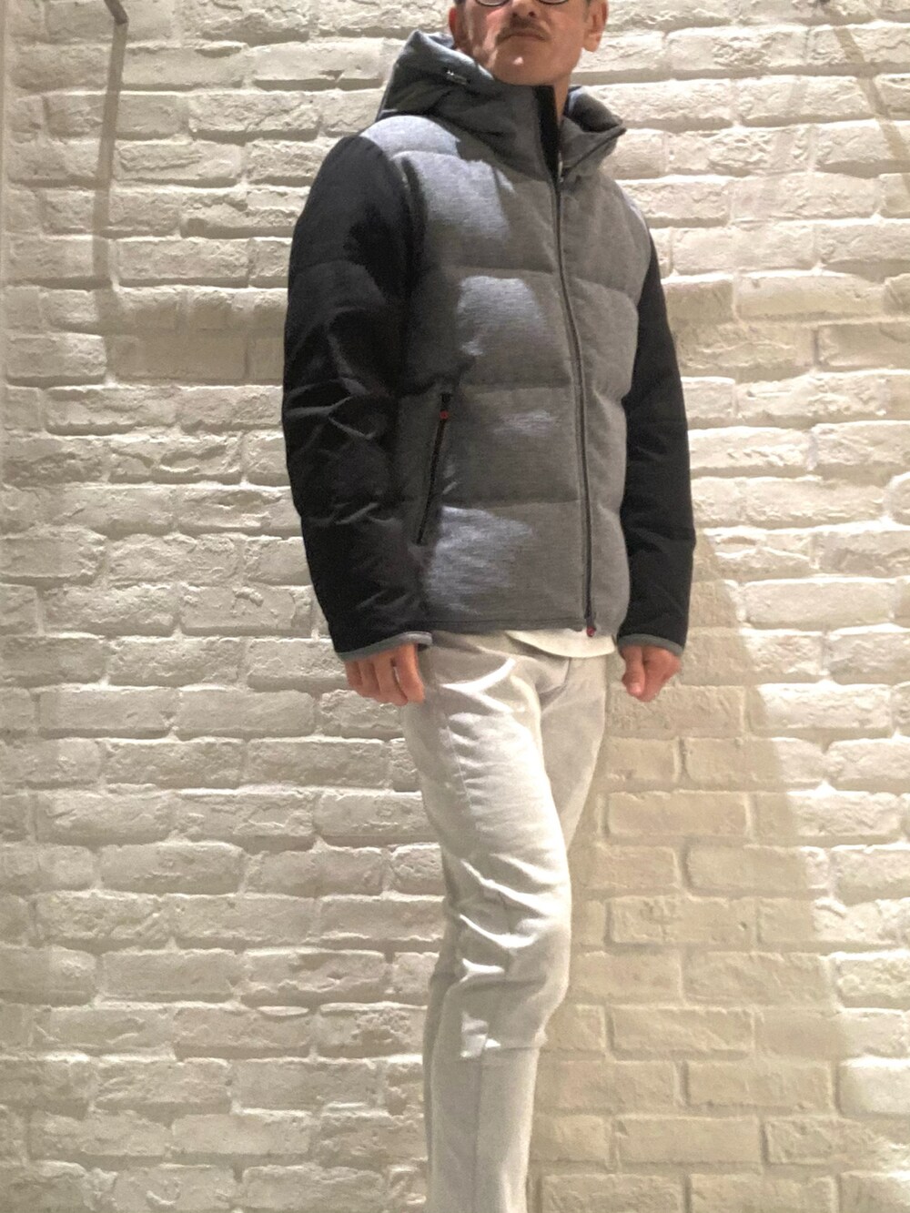 グレー系のダウンジャケット/コート、ホワイト系のTシャツ/カットソー、グレー系のその他パンツを着用したメンズの冬コーディネートの2枚目の写真
