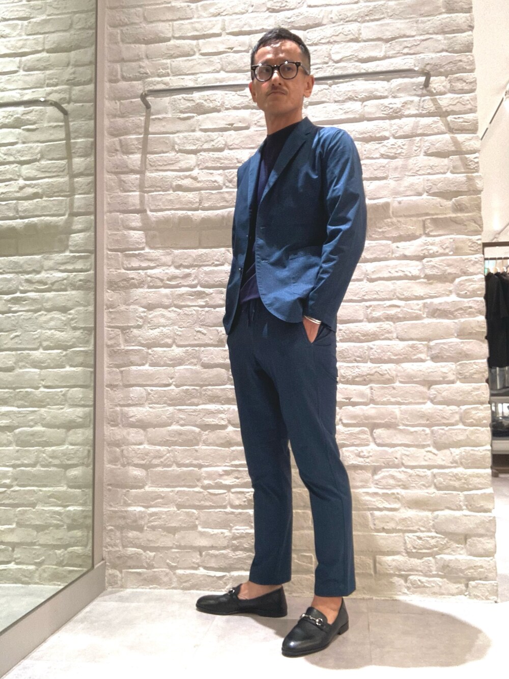 ブルー系のテーラードジャケット、ブルー系のスラックス、ブルー系のTシャツ/カットソーを着用したメンズの秋コーディネートの3枚目の写真