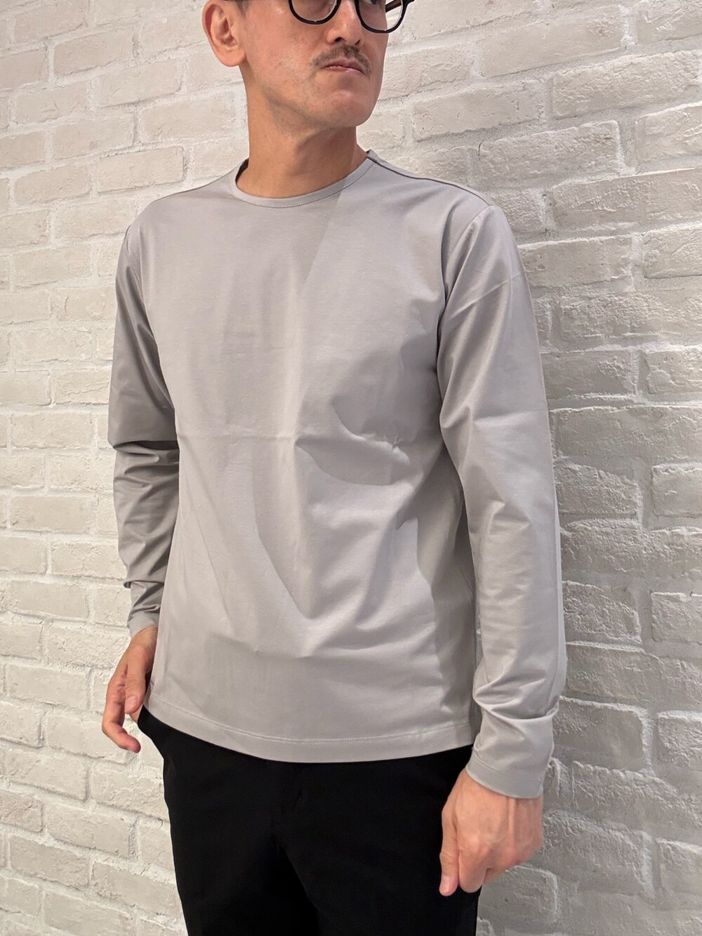 ベージュ系のTシャツ/カットソー、ブラック系のテーラードジャケット、ブラック系のセットアップを着用したメンズの秋コーディネートの4枚目の写真