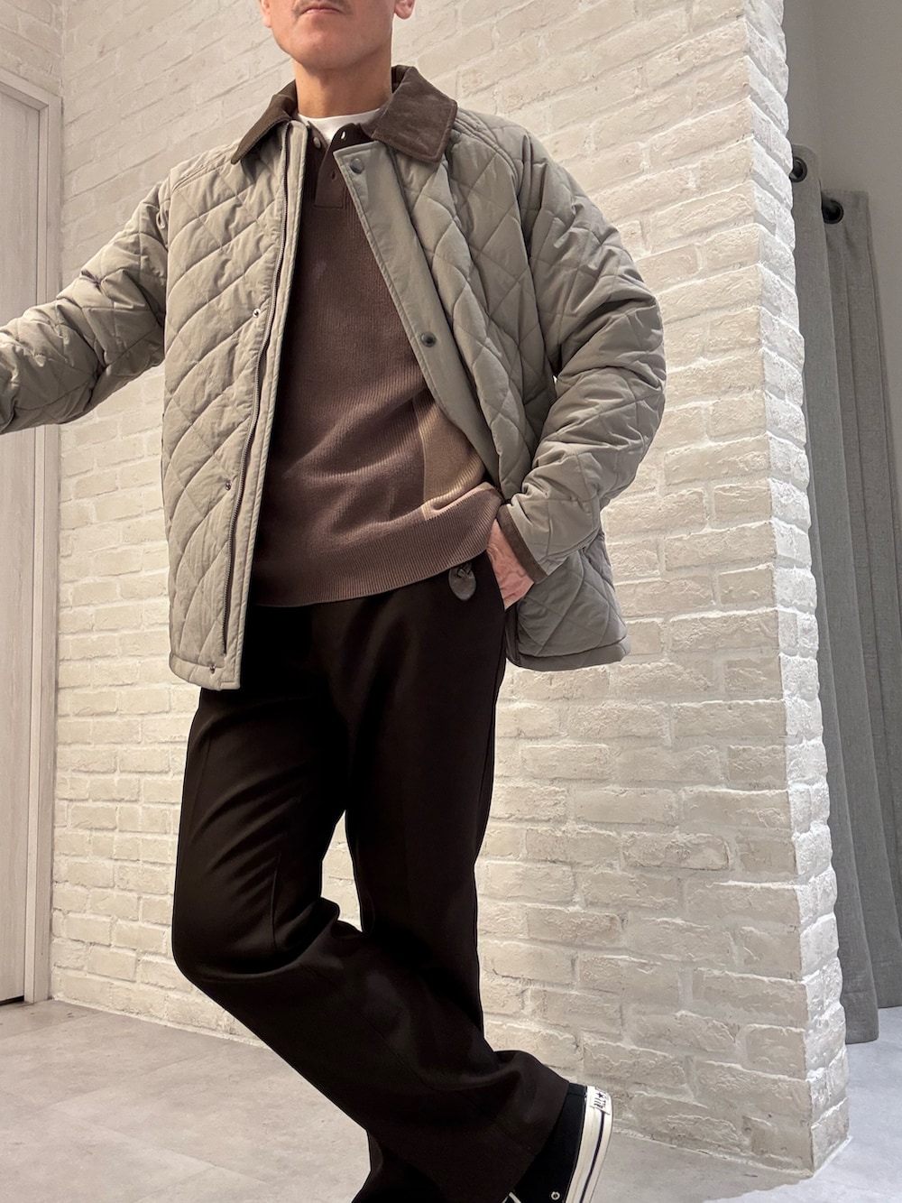 ブラウン系のブルゾン、ベージュ系のニット/セーター、ブラウン系のスラックスを着用したメンズの冬コーディネートの2枚目の写真