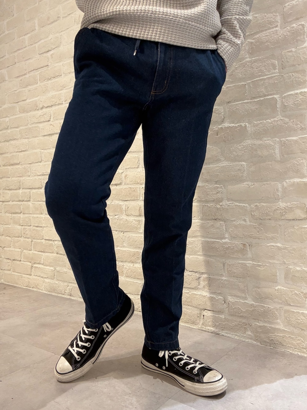 グリーン系のブルゾン、ベージュ系のTシャツ/カットソー、ブルー系のデニムパンツを着用したメンズの冬コーディネートの6枚目の写真