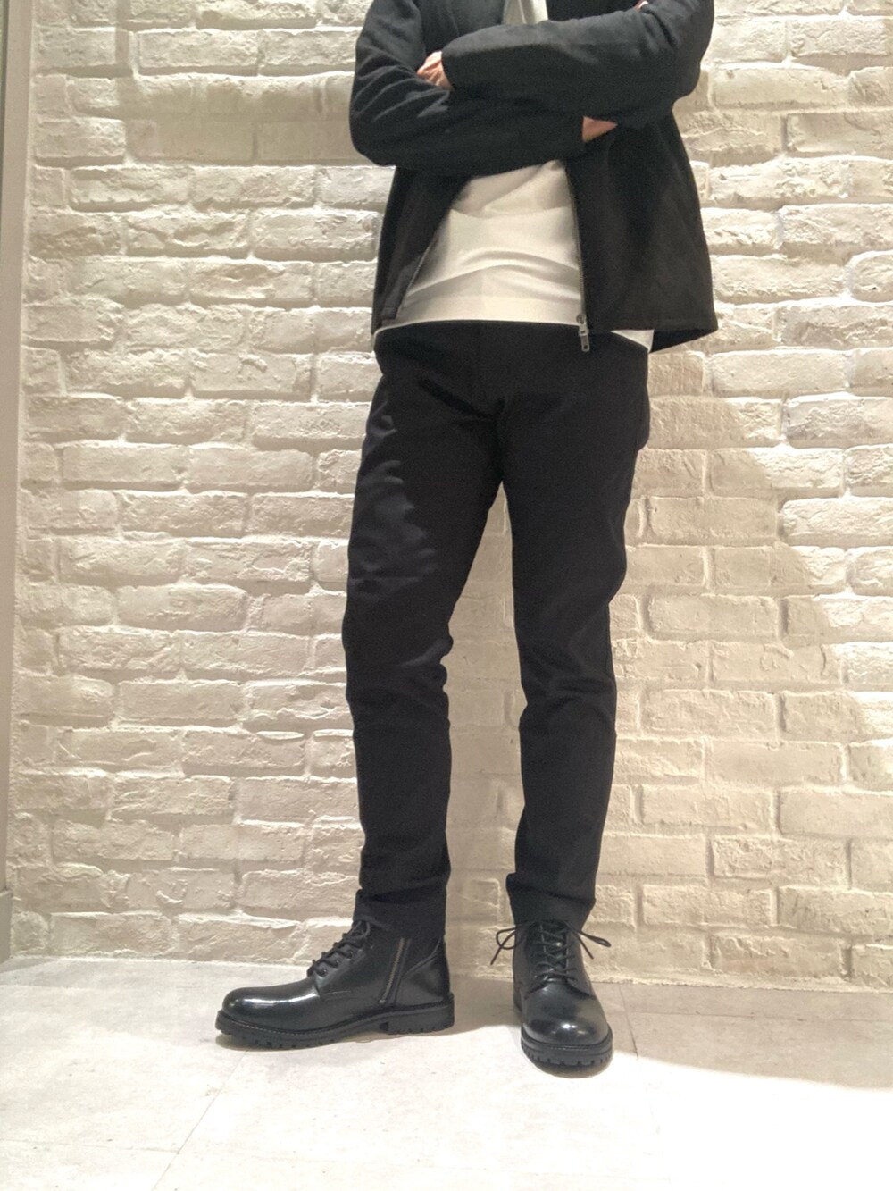 ブラック系のブルゾン、ホワイト系のTシャツ/カットソー、ブラック系のチノパンツを着用したメンズの秋コーディネートの5枚目の写真