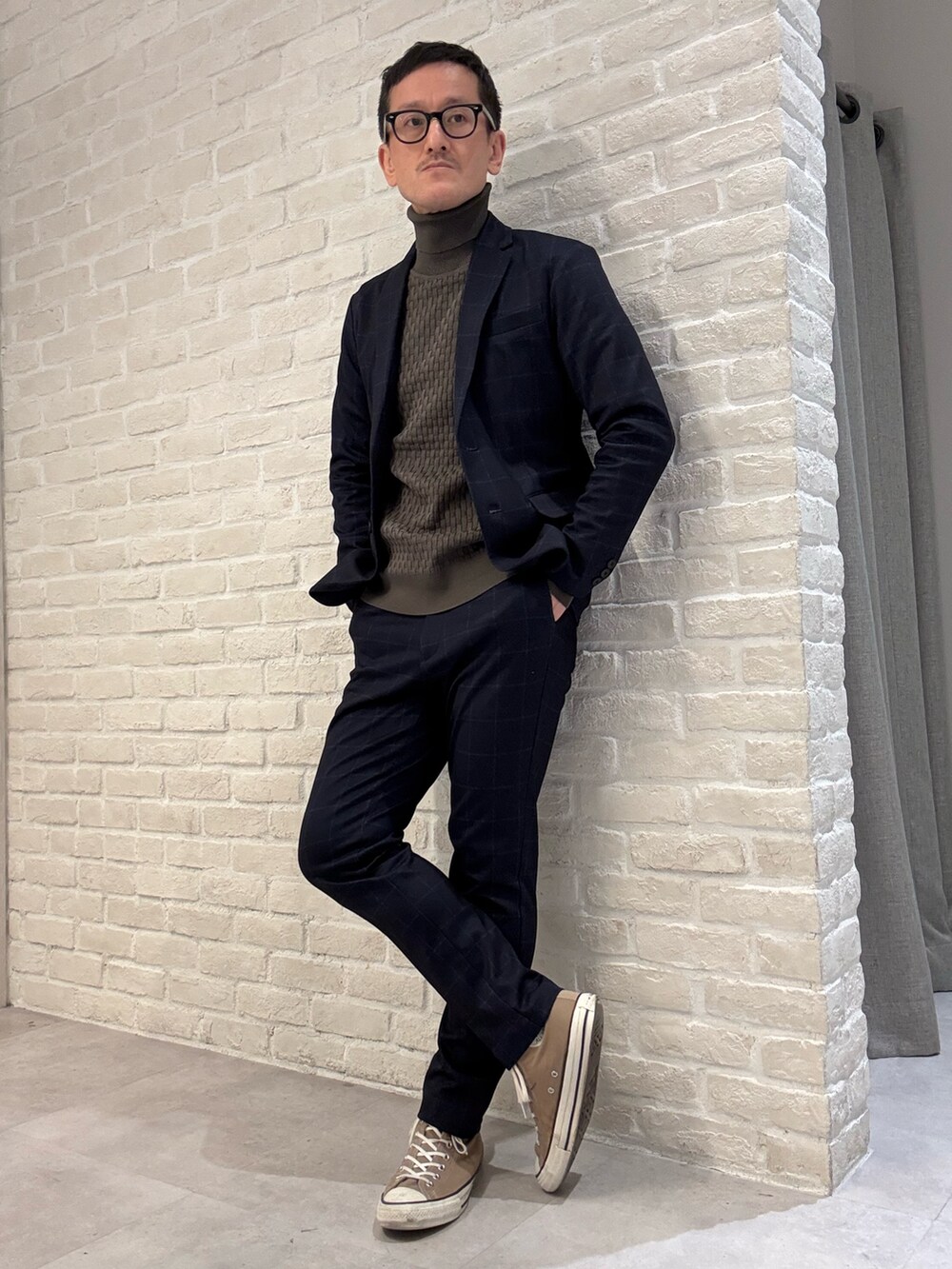 ブルー系のスラックス、ブルー系のテーラードジャケット、ブラウン系のニット/セーターを着用したメンズの冬コーディネートの2枚目の写真