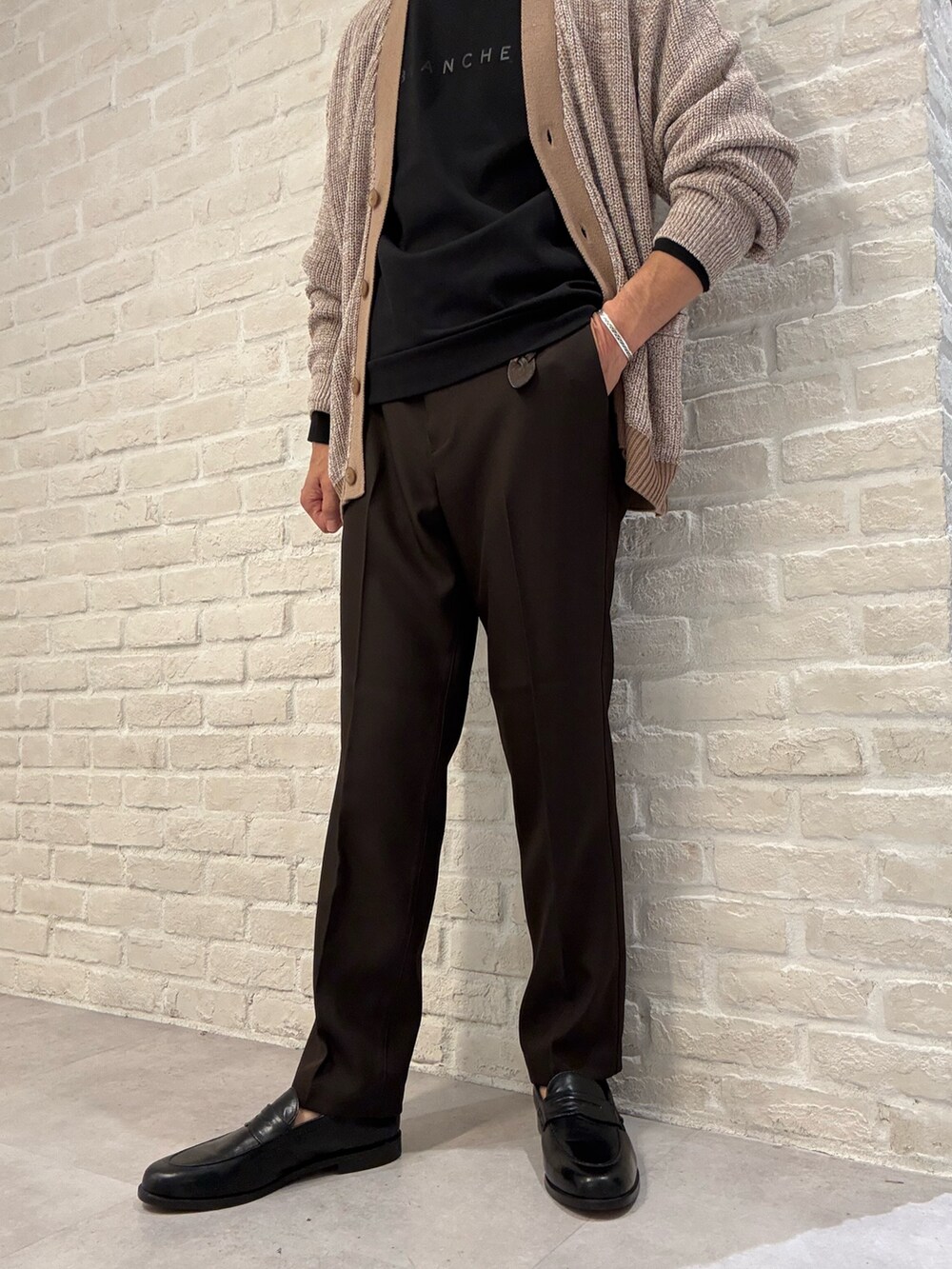 ベージュ系のカーディガン/ボレロ、ブラック系のTシャツ/カットソー、ブラウン系のスラックスを着用したメンズの秋コーディネートの3枚目の写真