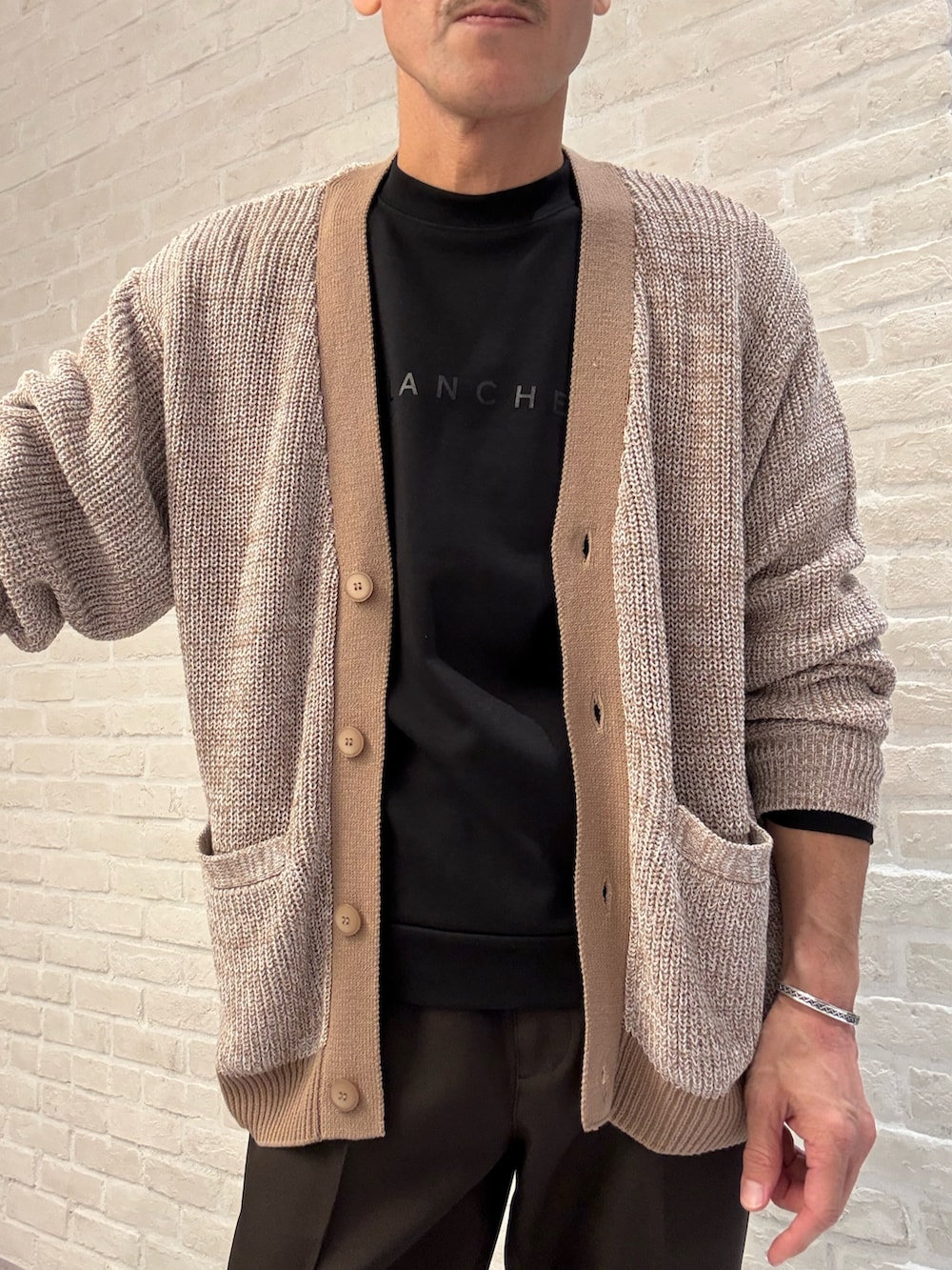 ベージュ系のカーディガン/ボレロ、ブラック系のTシャツ/カットソー、ブラウン系のスラックスを着用したメンズの秋コーディネートの4枚目の写真