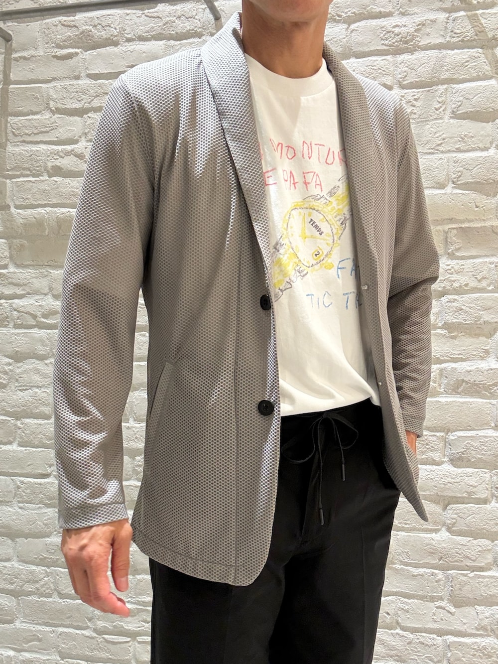 ブラウン系のブルゾン、ホワイト系のTシャツ/カットソー、ブラック系のその他パンツを着用したメンズの夏コーディネートの2枚目の写真