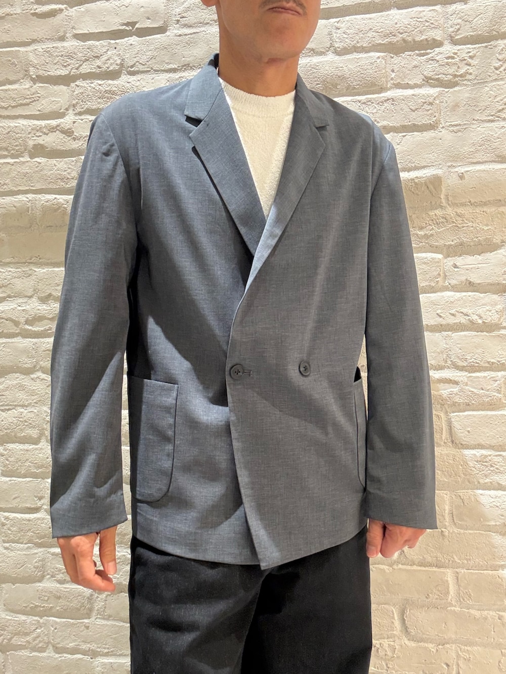 ブルー系のテーラードジャケット、ホワイト系のTシャツ/カットソー、ブラック系のデニムパンツを着用したメンズの秋コーディネートの3枚目の写真