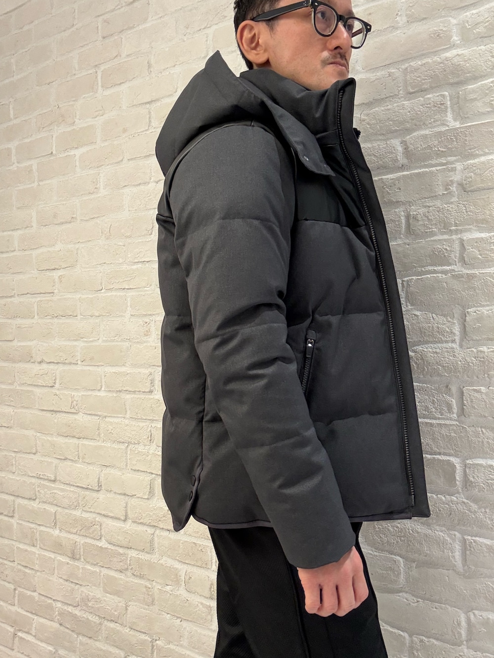 ブラック系のTシャツ/カットソー、グレー系のダウンジャケット/コート、ブラック系のその他パンツを着用したメンズの冬コーディネートの3枚目の写真