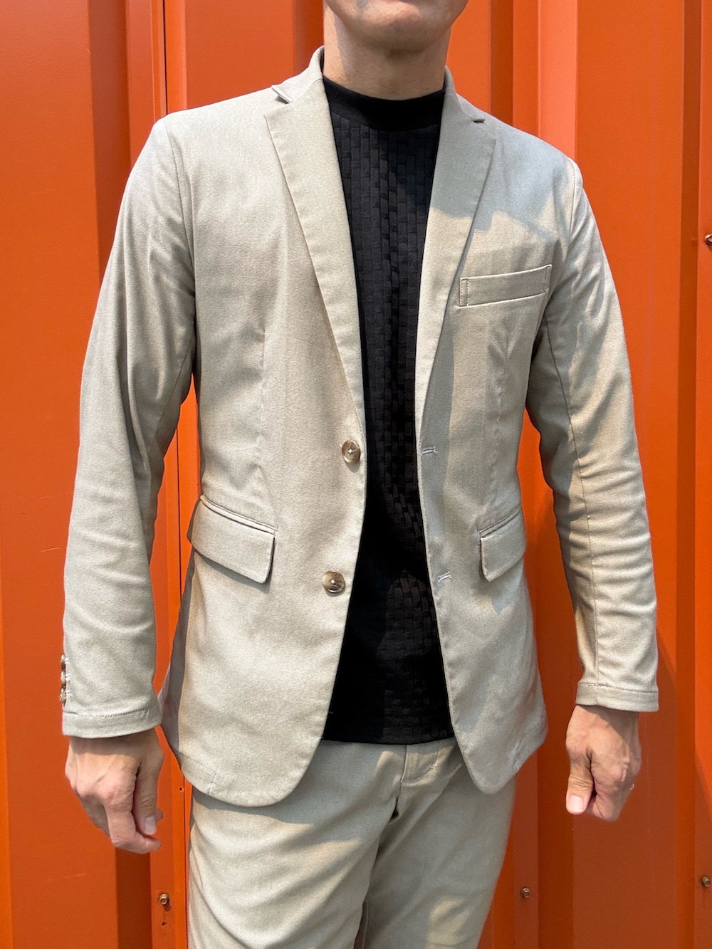 ベージュ系のセットアップ、ベージュ系のテーラードジャケット、ブラック系のTシャツ/カットソーを着用したメンズの夏コーディネートの2枚目の写真