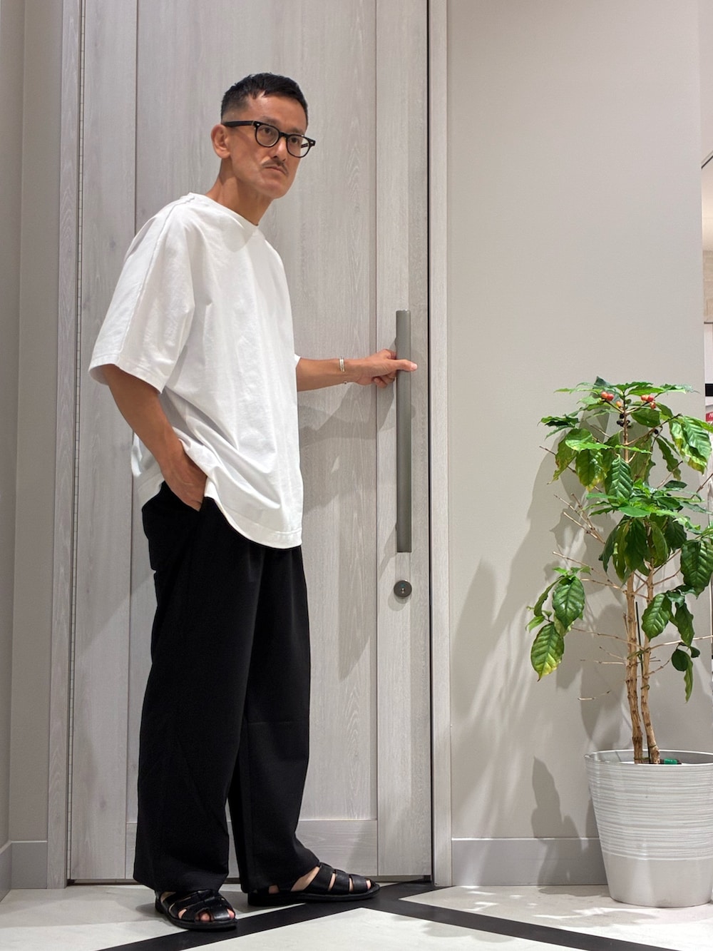 ブルー系のバックパック/リュック、ホワイト系のTシャツ/カットソー、ブラック系のその他パンツを着用したメンズの夏コーディネートの3枚目の写真