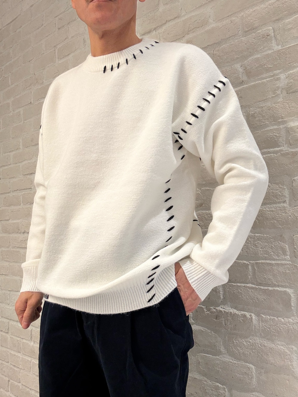 ブルー系のその他パンツ、ホワイト系のニット/セーター、ブルー系のブルゾンを着用したメンズの冬コーディネートの3枚目の写真