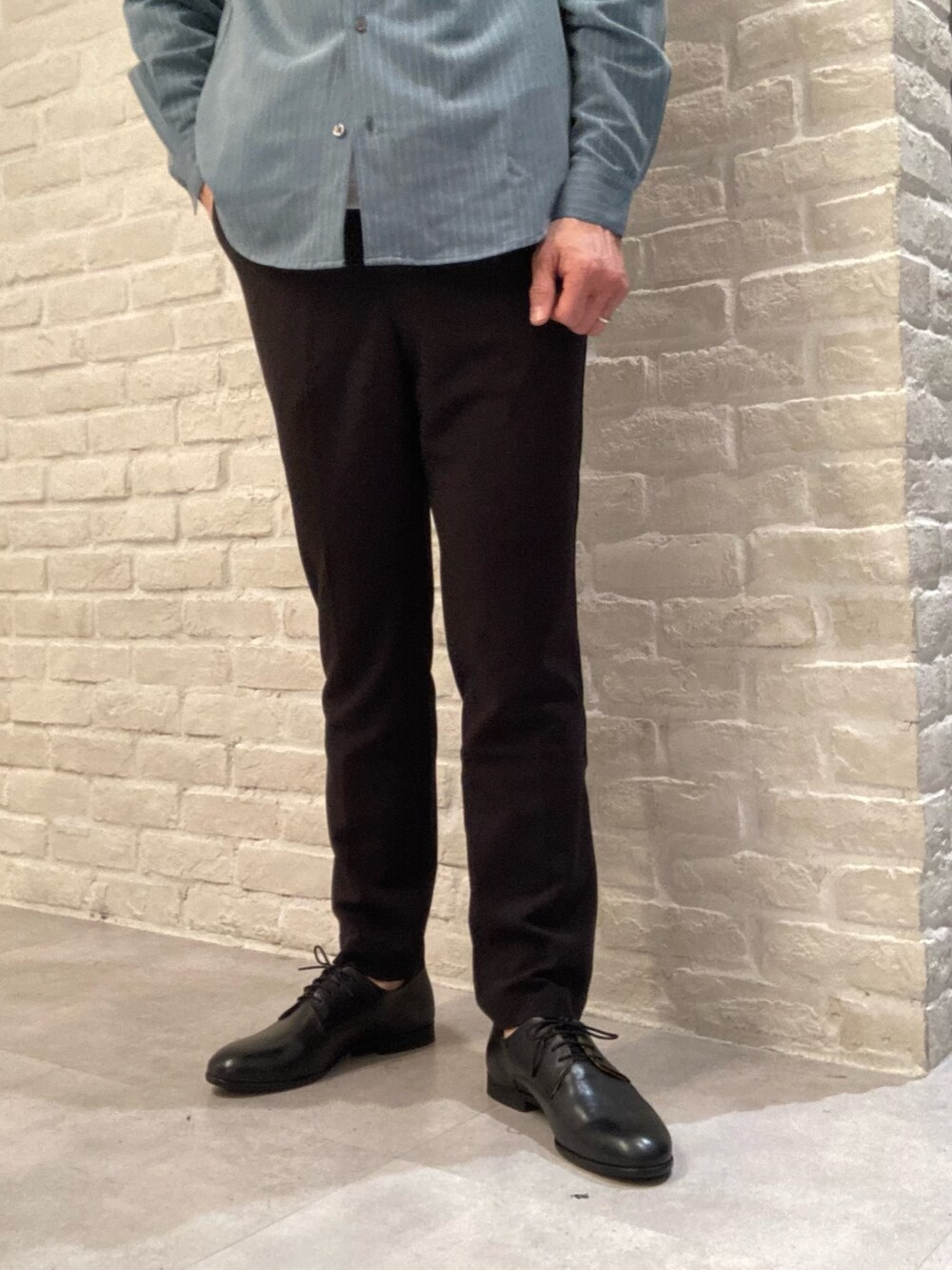 グリーン系のシャツ/ブラウス、ホワイト系のTシャツ/カットソー、ブラック系のスラックスを着用したメンズの春コーディネートの3枚目の写真