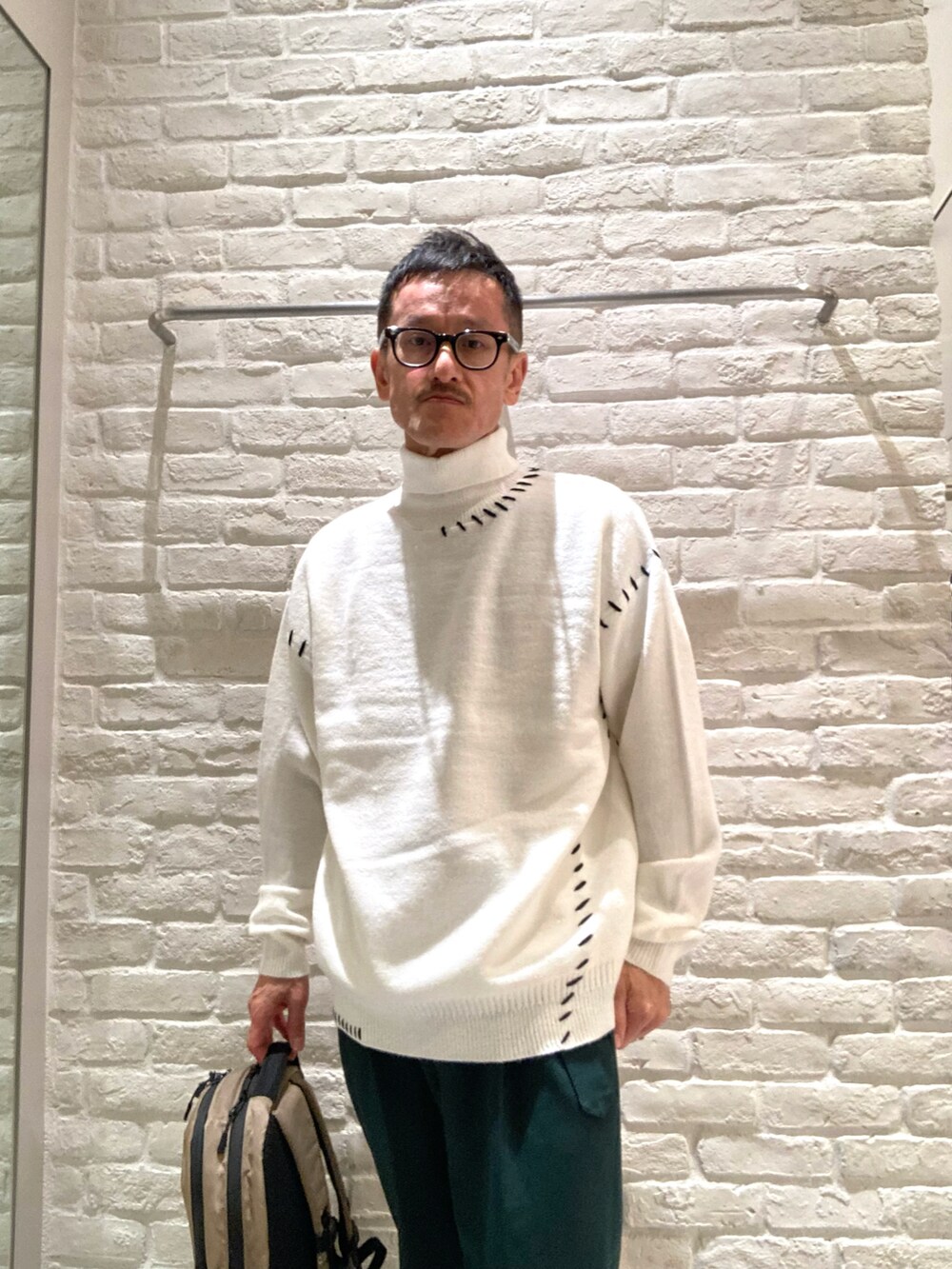 ホワイト系のニット/セーター、グリーン系のその他パンツを着用したメンズの秋コーディネートの4枚目の写真