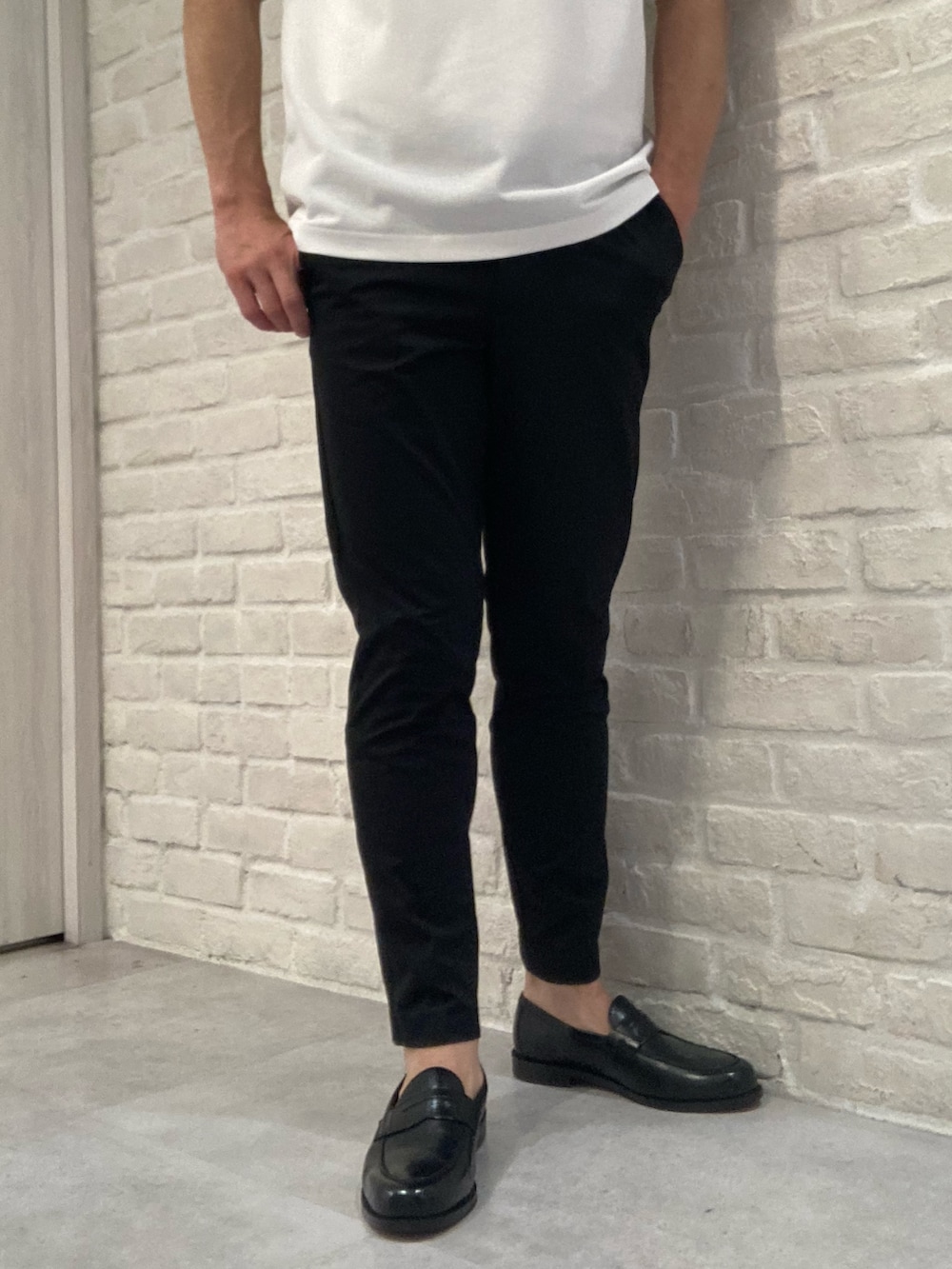 グレー系のブルゾン、ホワイト系のTシャツ/カットソー、ブラック系のスラックスを着用したメンズの夏コーディネートの5枚目の写真