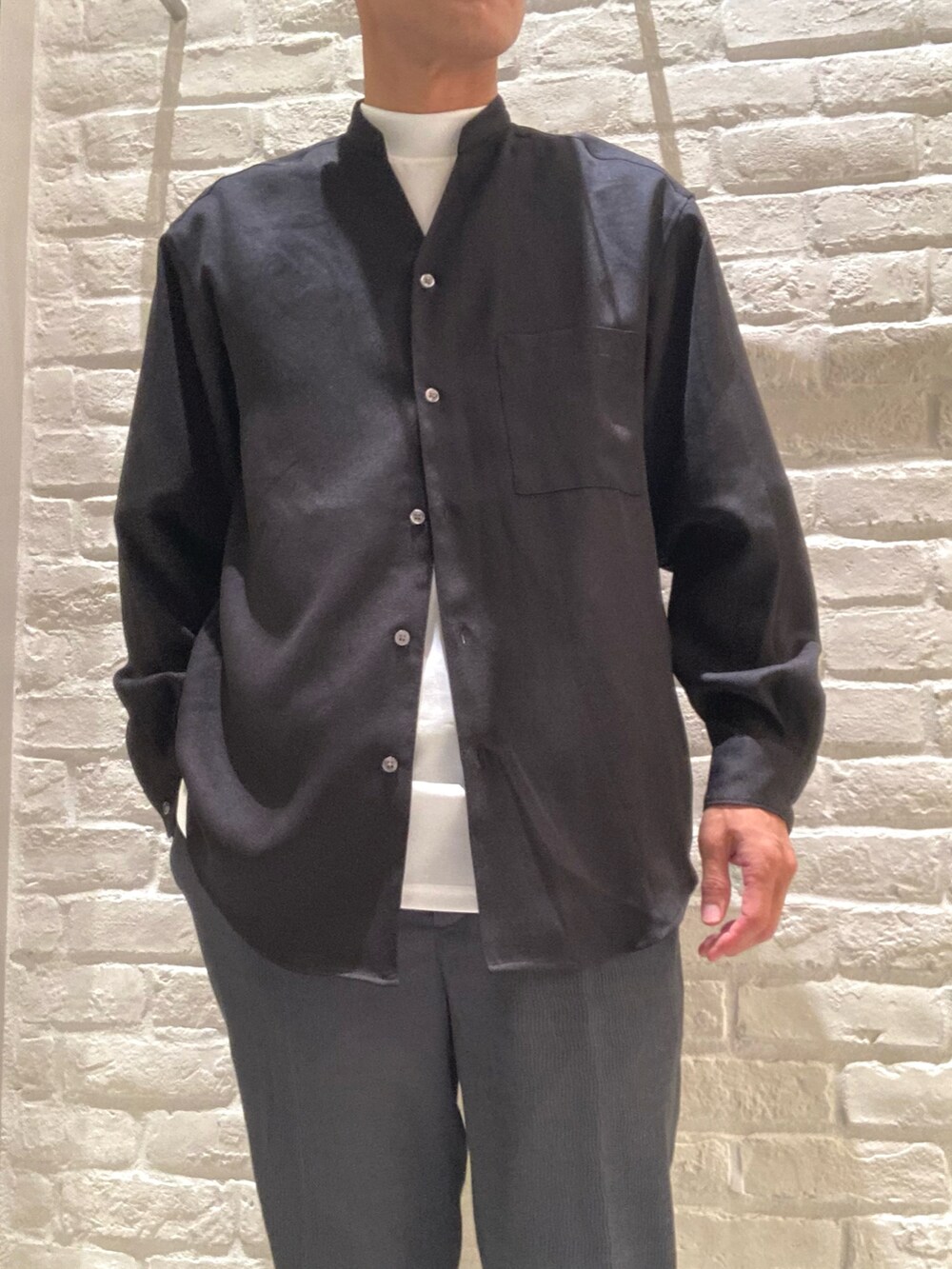 ブラック系のシャツ/ブラウス、ホワイト系のTシャツ/カットソー、グレー系のスラックスを着用したメンズの秋コーディネートの2枚目の写真