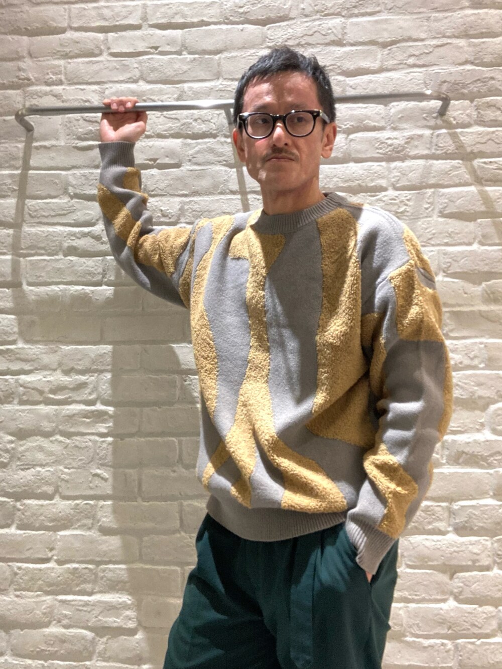 ホワイト系のブルゾン、グレー系のニット/セーター、グリーン系のその他パンツを着用したメンズの冬コーディネートの4枚目の写真