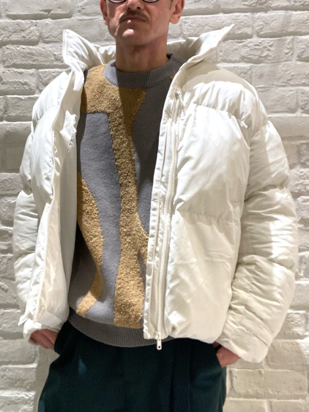 ホワイト系のブルゾン、グレー系のニット/セーター、グリーン系のその他パンツを着用したメンズの冬コーディネートの5枚目の写真