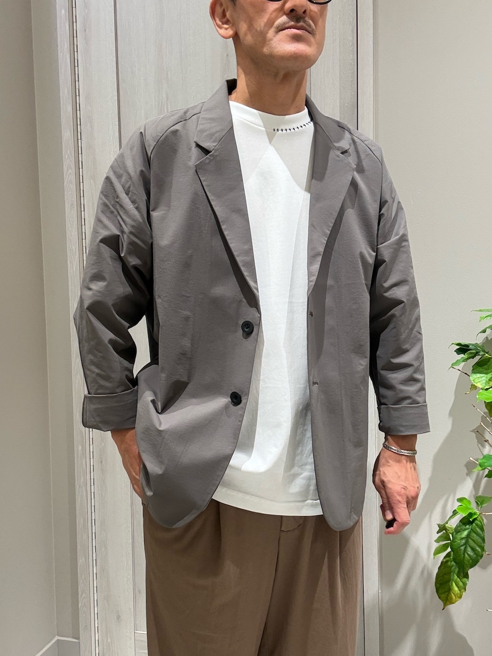 グレー系のテーラードジャケット、ホワイト系のTシャツ/カットソー、ブラウン系のその他パンツを着用したメンズの夏コーディネートの2枚目の写真