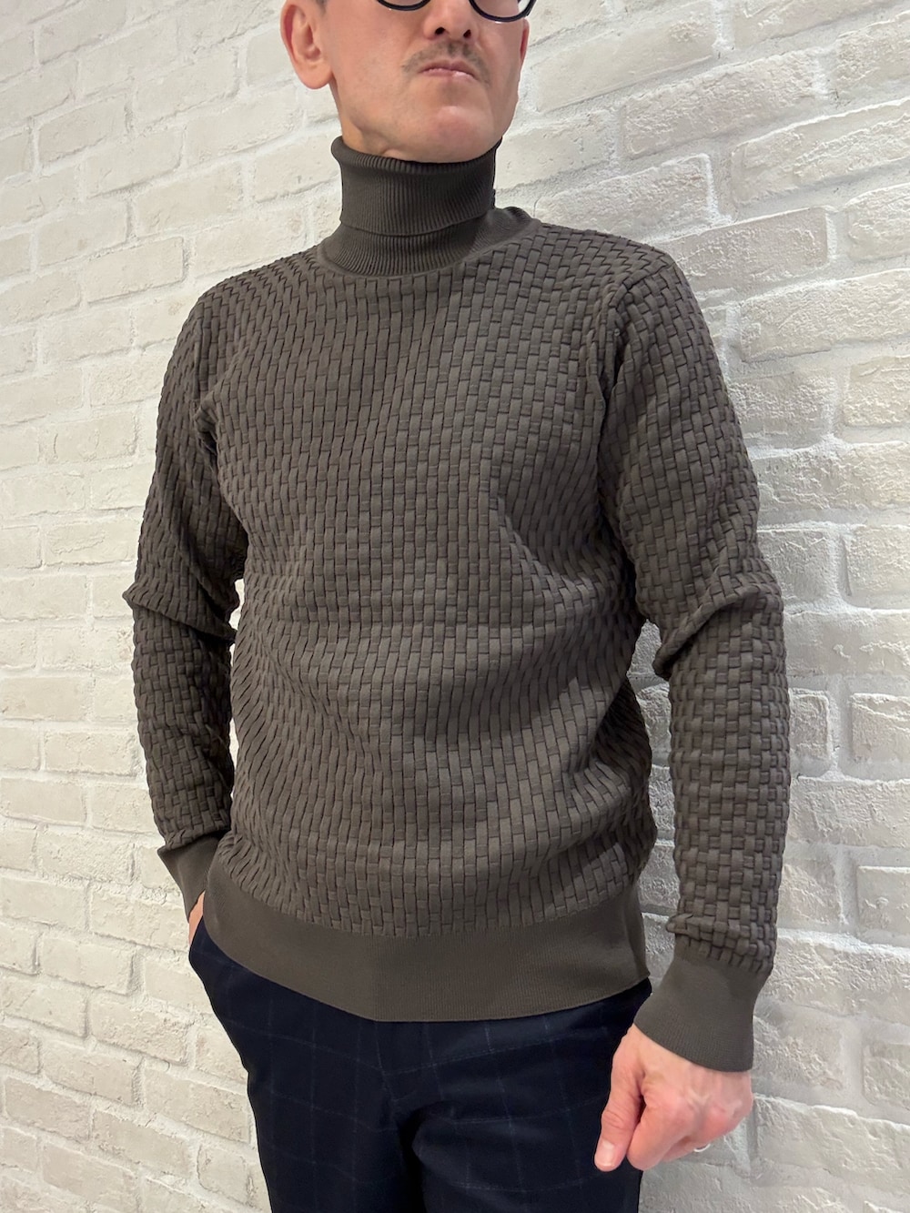 ブルー系のスラックス、ブルー系のテーラードジャケット、ブラウン系のニット/セーターを着用したメンズの冬コーディネートの4枚目の写真