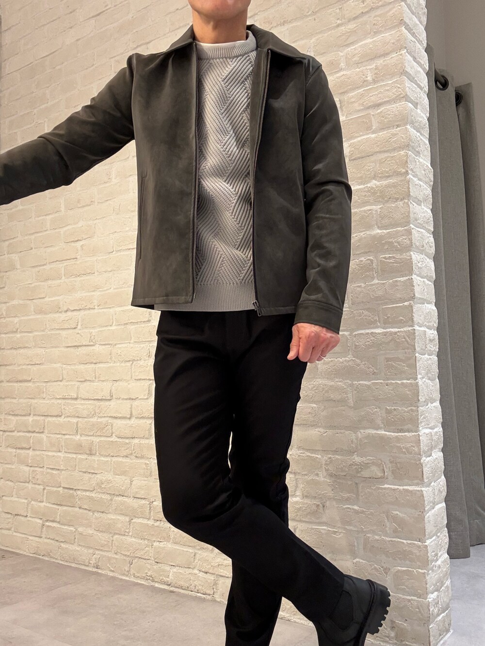 ブラック系のブルゾン、グレー系のニット/セーター、ブラック系のその他パンツを着用したメンズの冬コーディネートの2枚目の写真