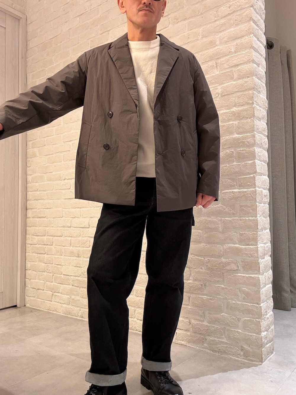 ブラウン系のブルゾン、ホワイト系のニット/セーターを着用したメンズの冬コーディネートの2枚目の写真