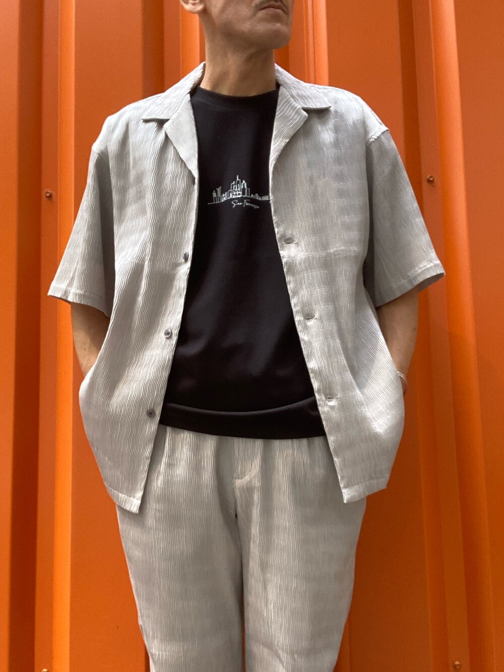 ベージュ系のシャツ/ブラウス、ブラック系のTシャツ/カットソー、ベージュ系のスラックスを着用したメンズの春コーディネートの4枚目の写真